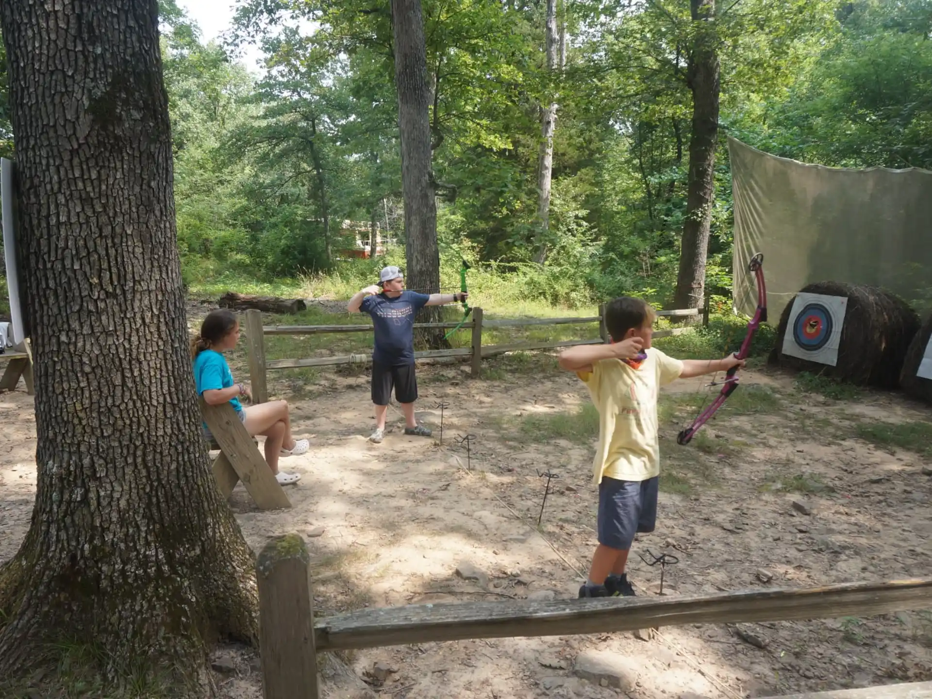 a group of people playing with sticks in a park