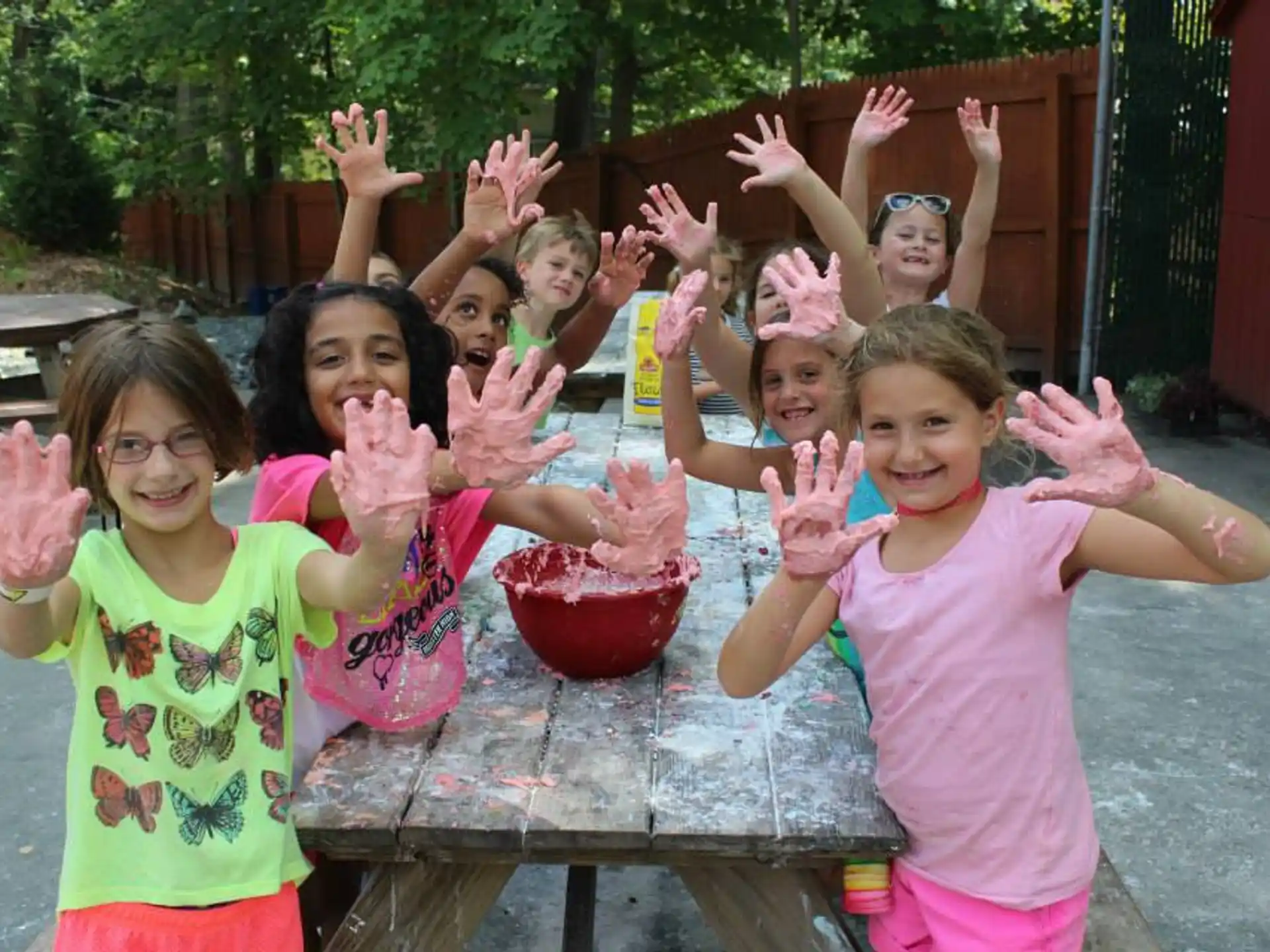 a group of children with their hands up in the air