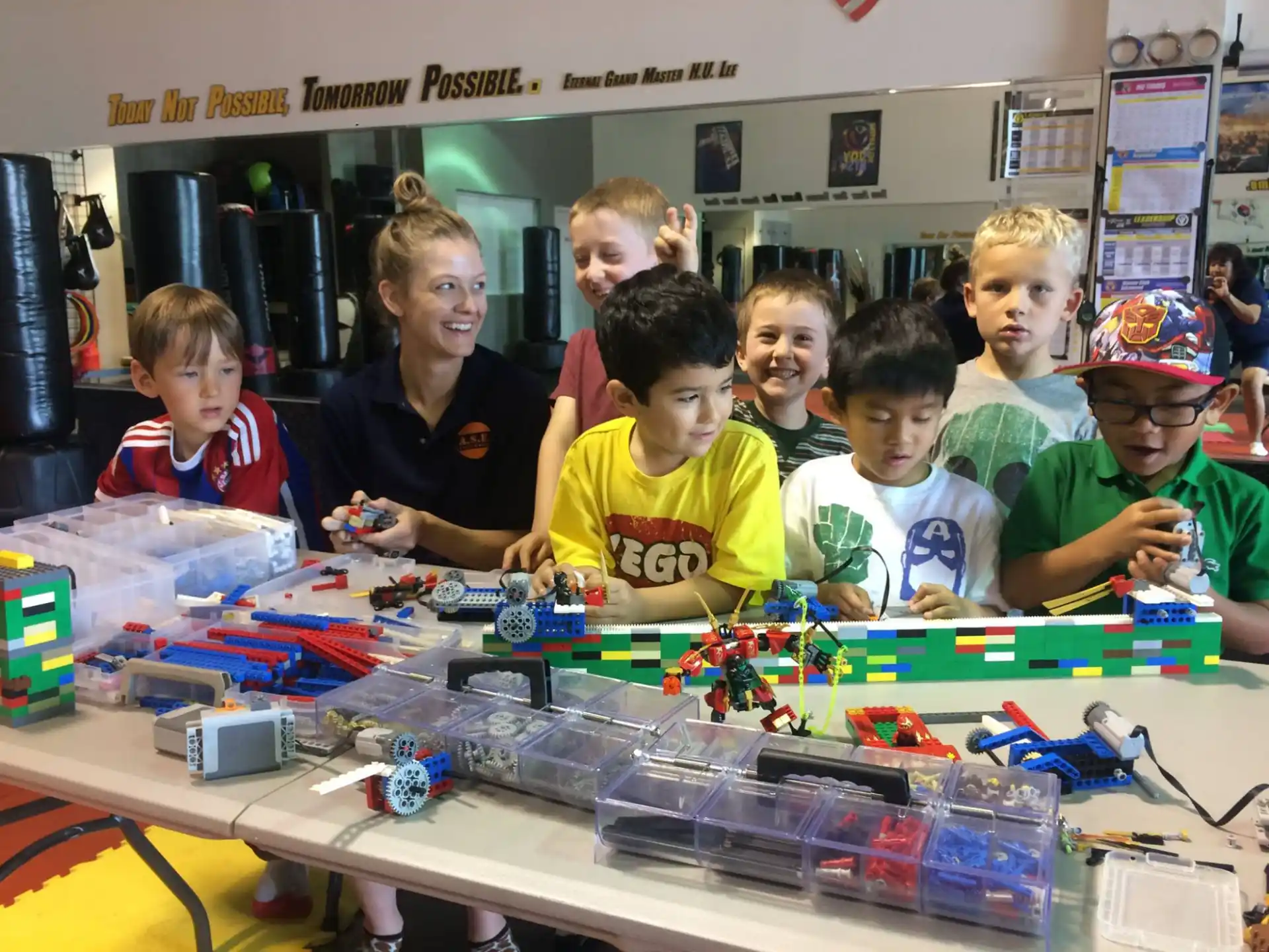 a group of kids posing for a picture with a table full of toys