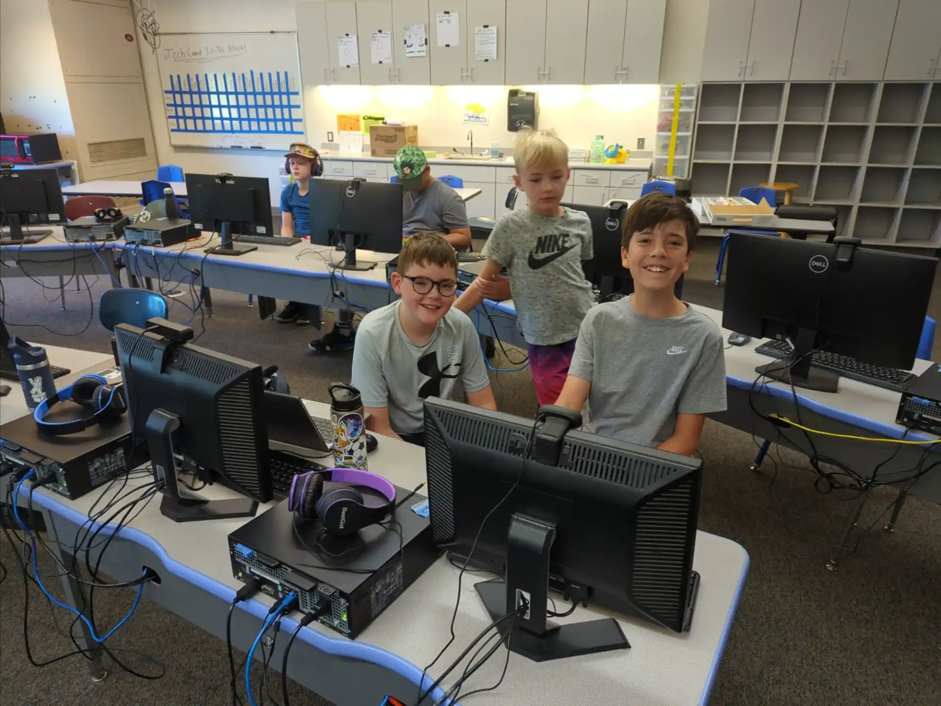 a group of people in a room with computers and other equipment