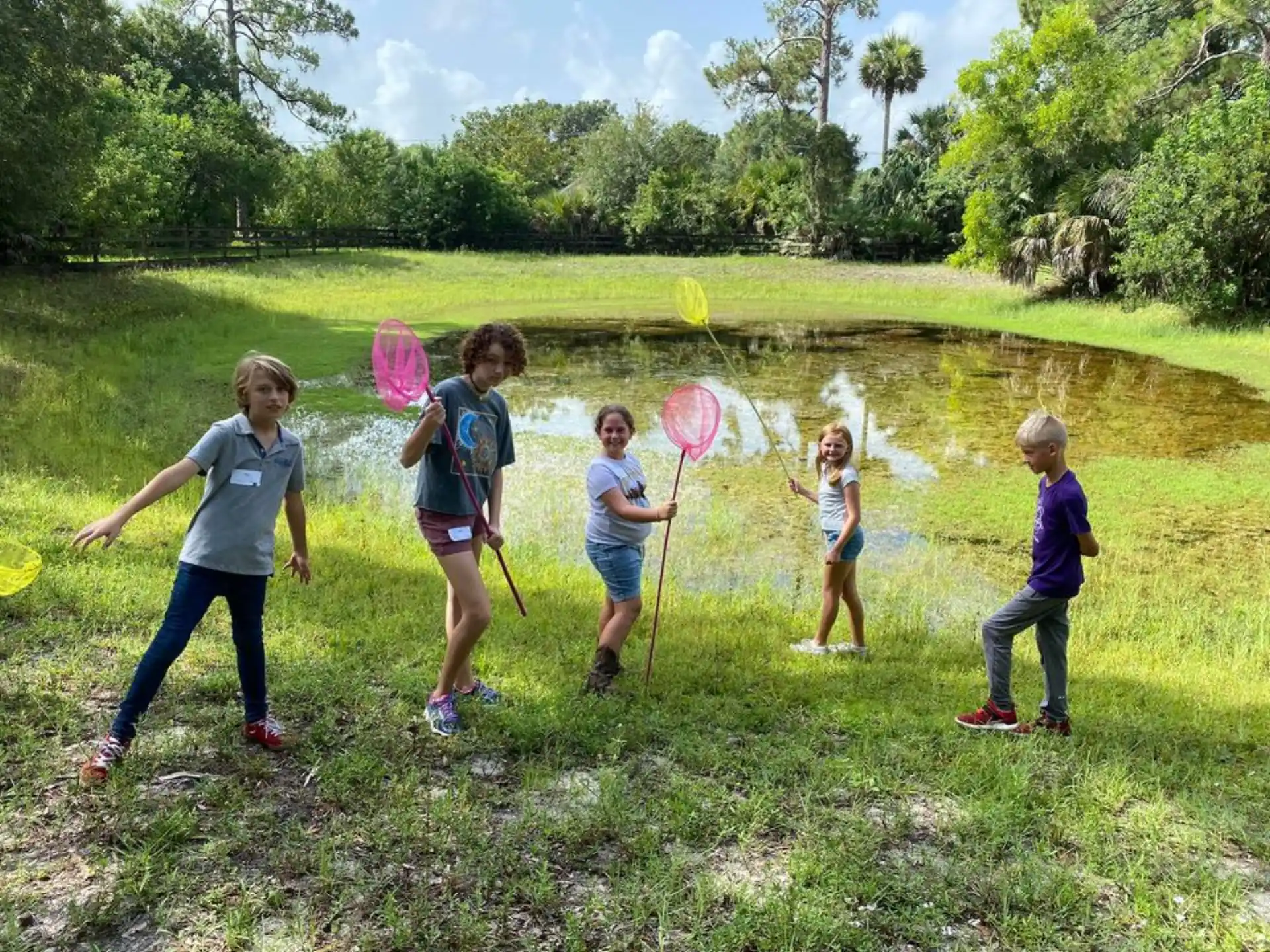 a group of children playing in a pond