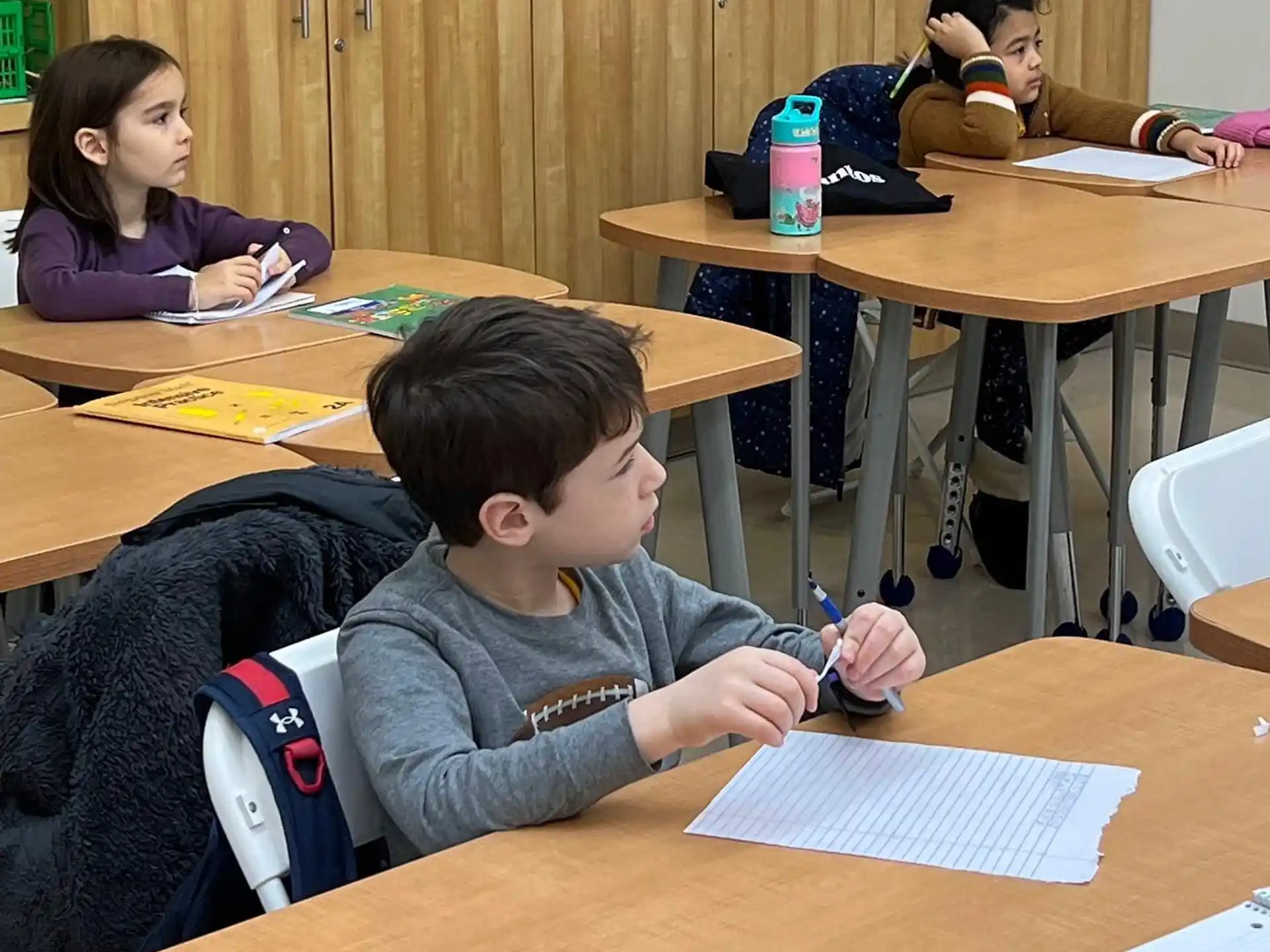 a group of people sitting at desks in a classroom