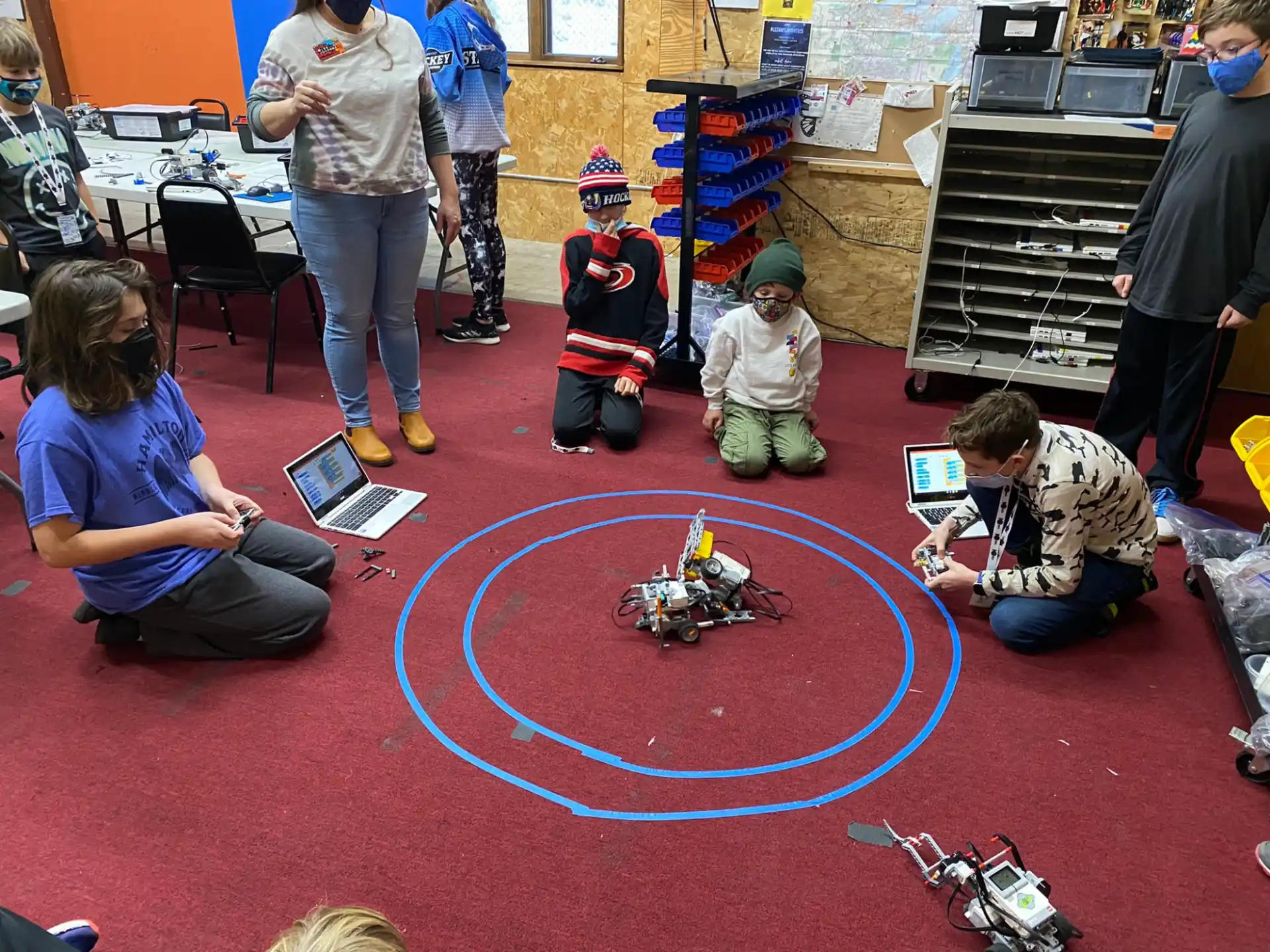 a group of people sitting on the floor looking at a toy train