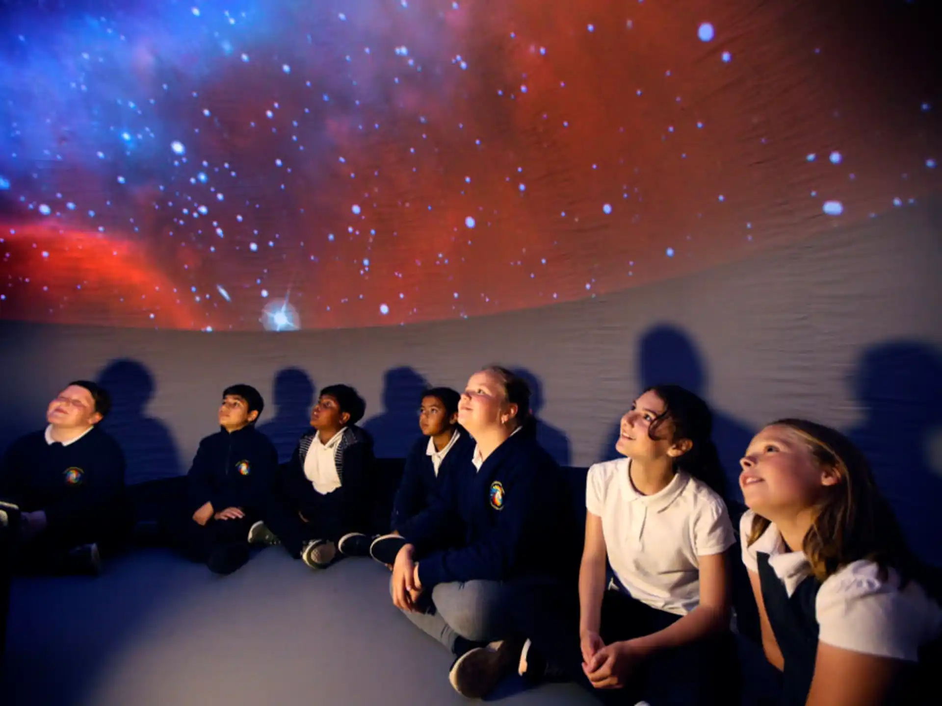 a group of people sitting on a stage with a bright light behind them