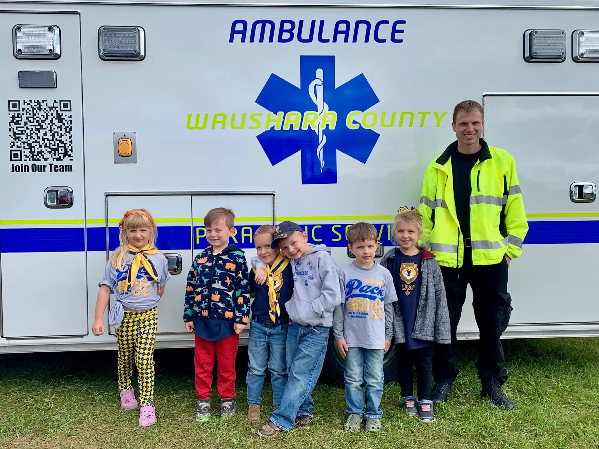 a group of children standing in front of a truck