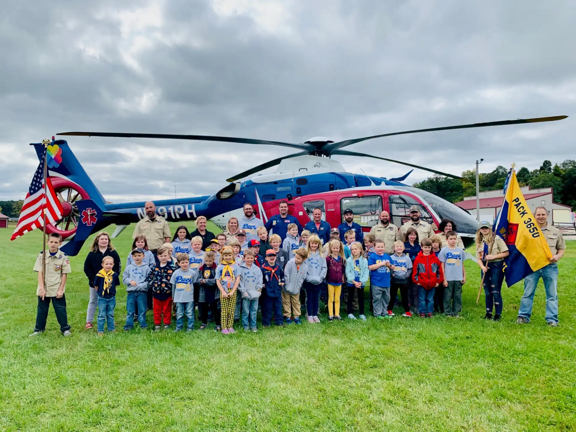 a group of people posing for a photo in front of a helicopter