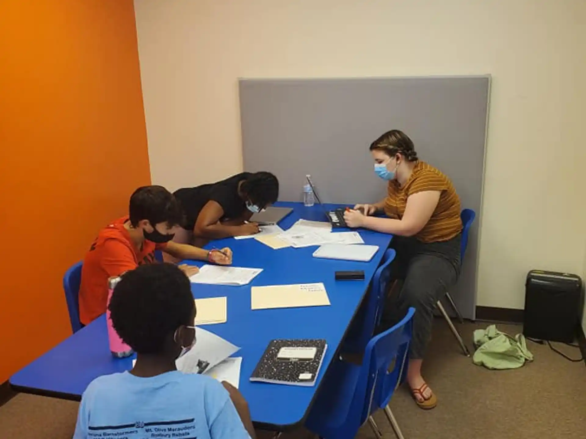 a group of people sitting at a table with a person standing behind them