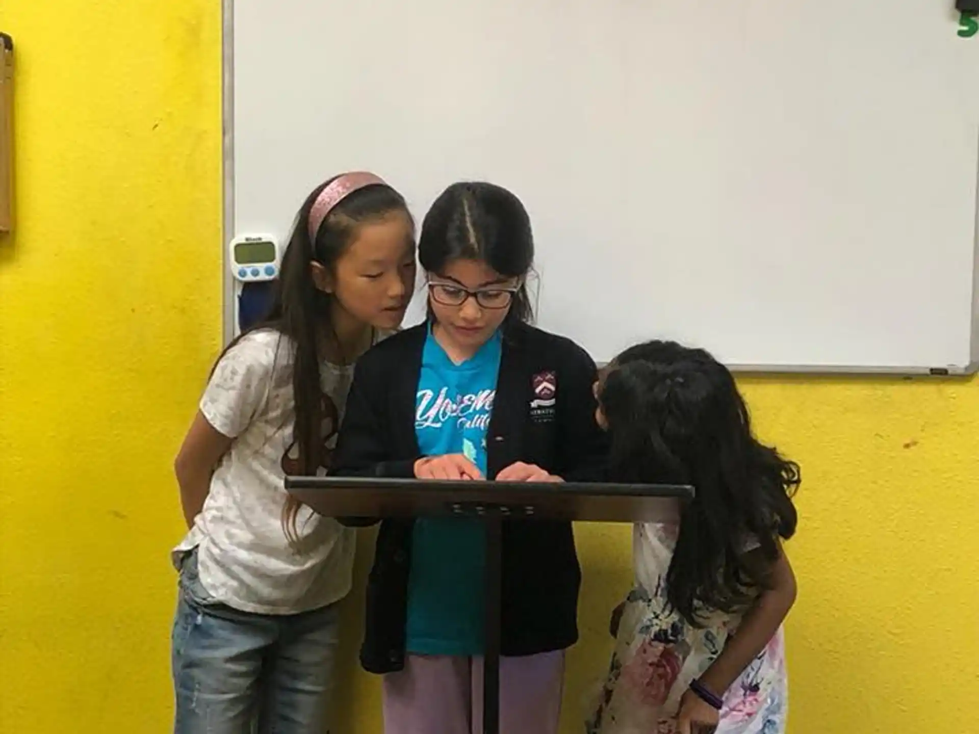 a group of girls standing in front of a white board