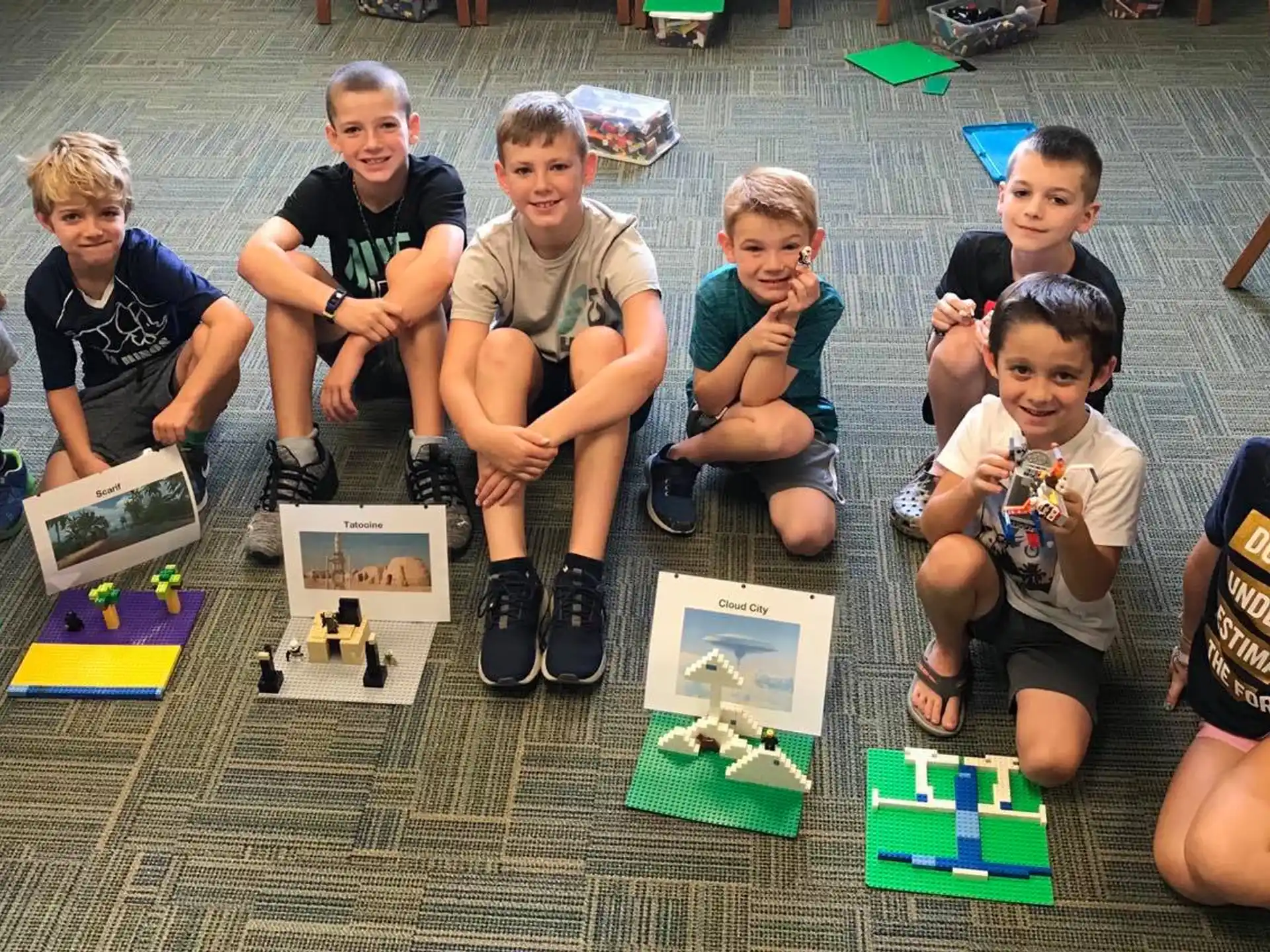 a group of people sitting on the floor with boxes and playing a board game