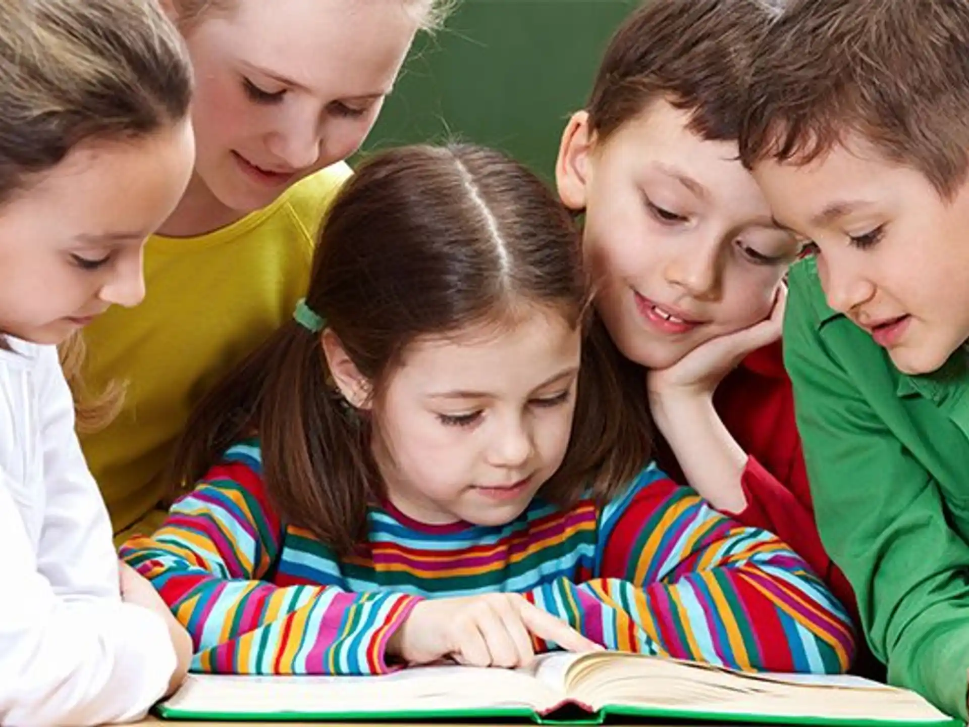 a group of children looking at a book