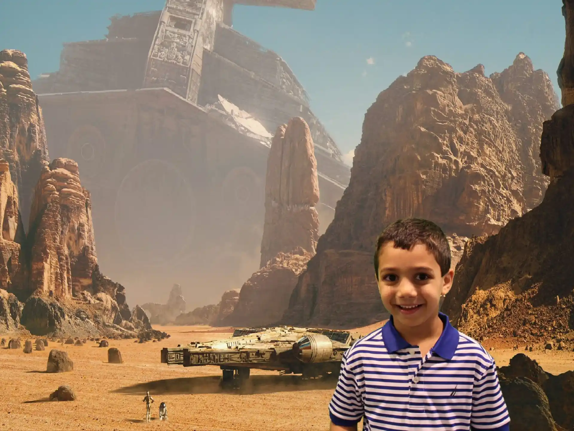 a boy standing in front of a desert landscape with a building and mountains