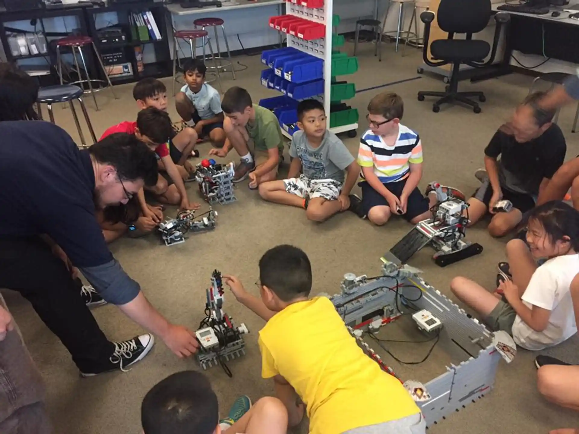 a group of people sitting on the floor with laptops