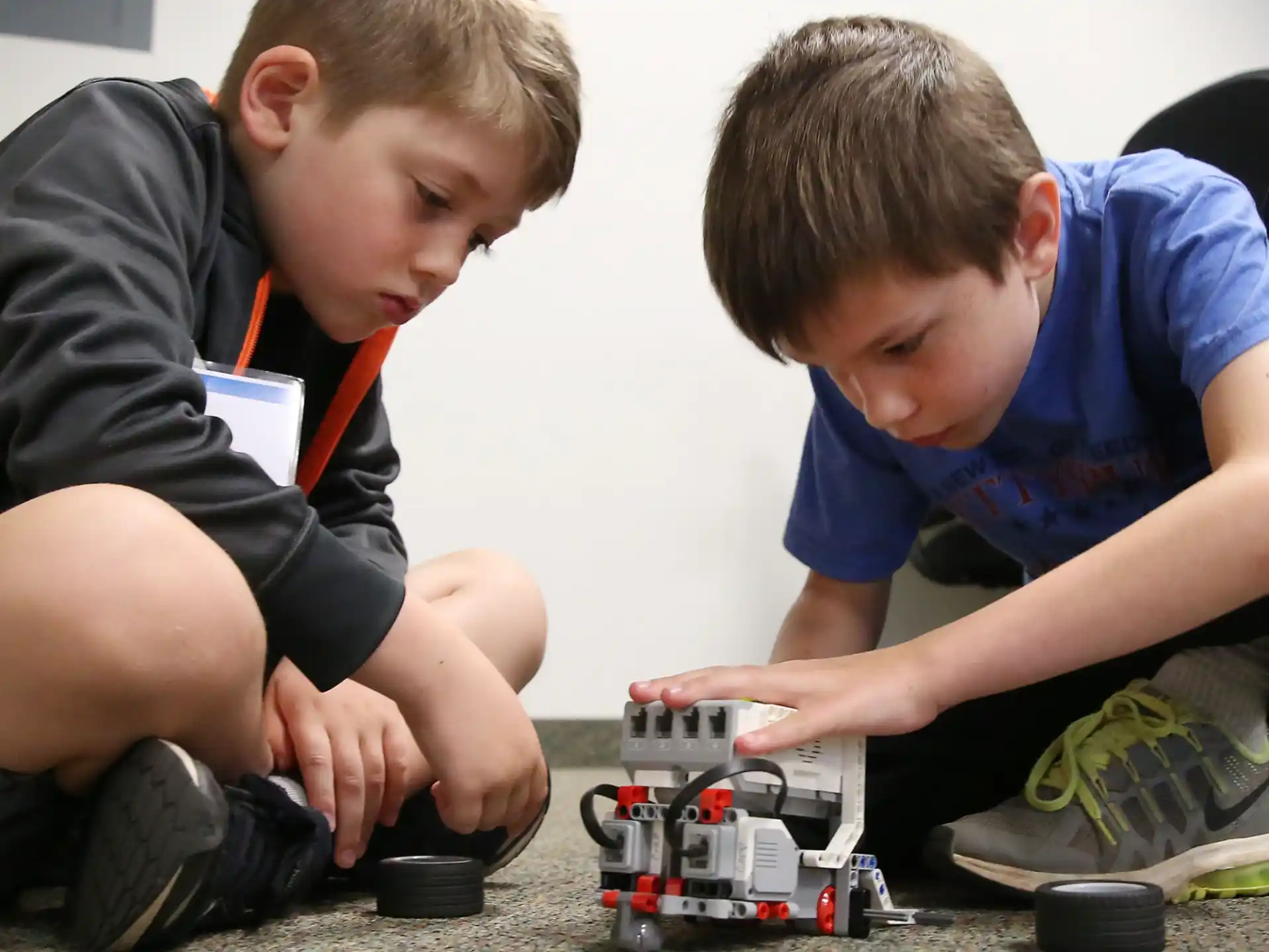 a couple of boys playing with a toy train
