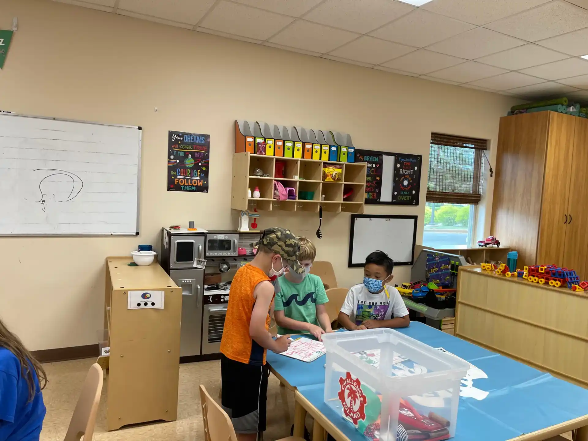a person and a boy in a room with a table and shelves