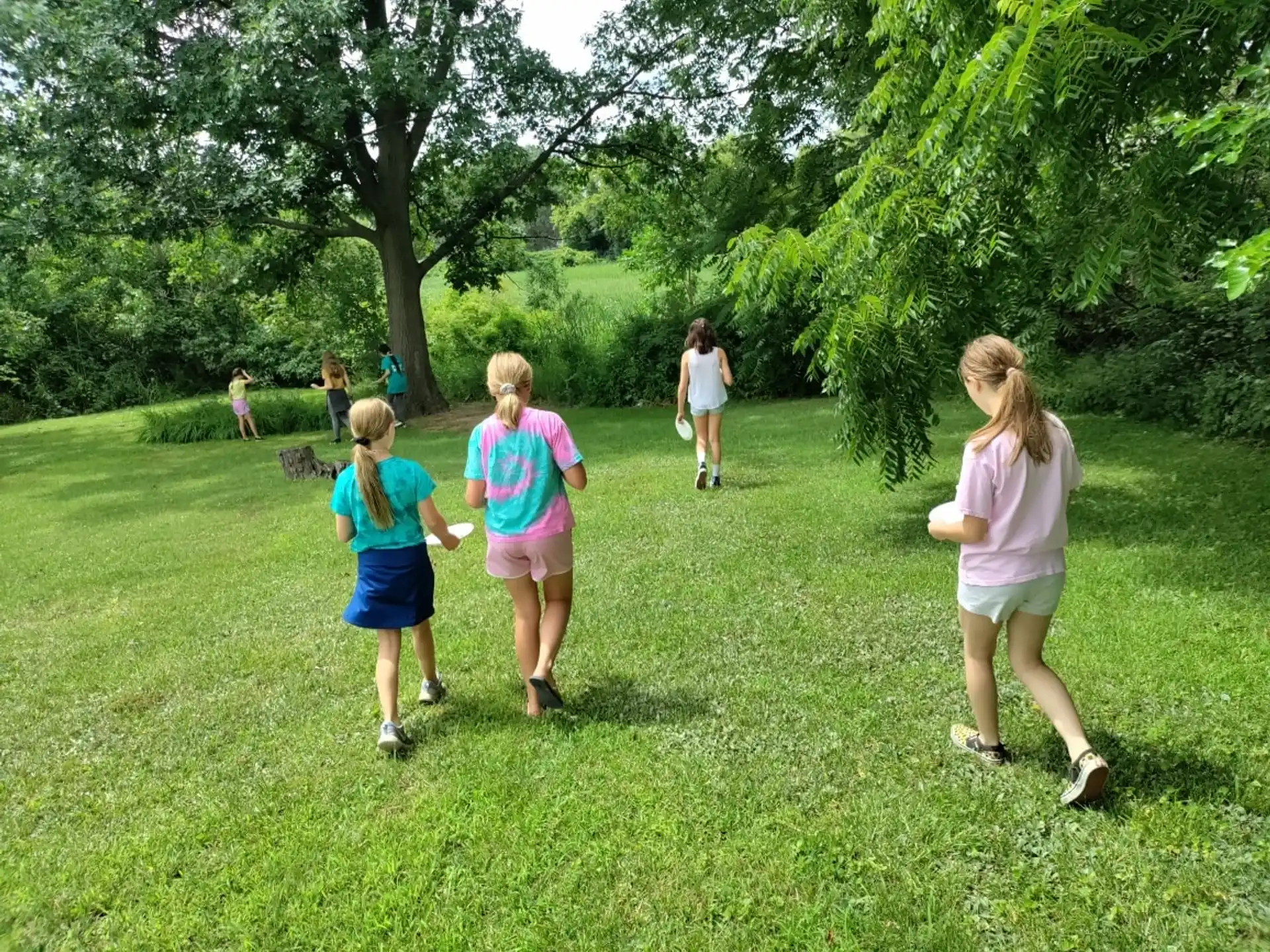 a group of people playing frisbee in a park