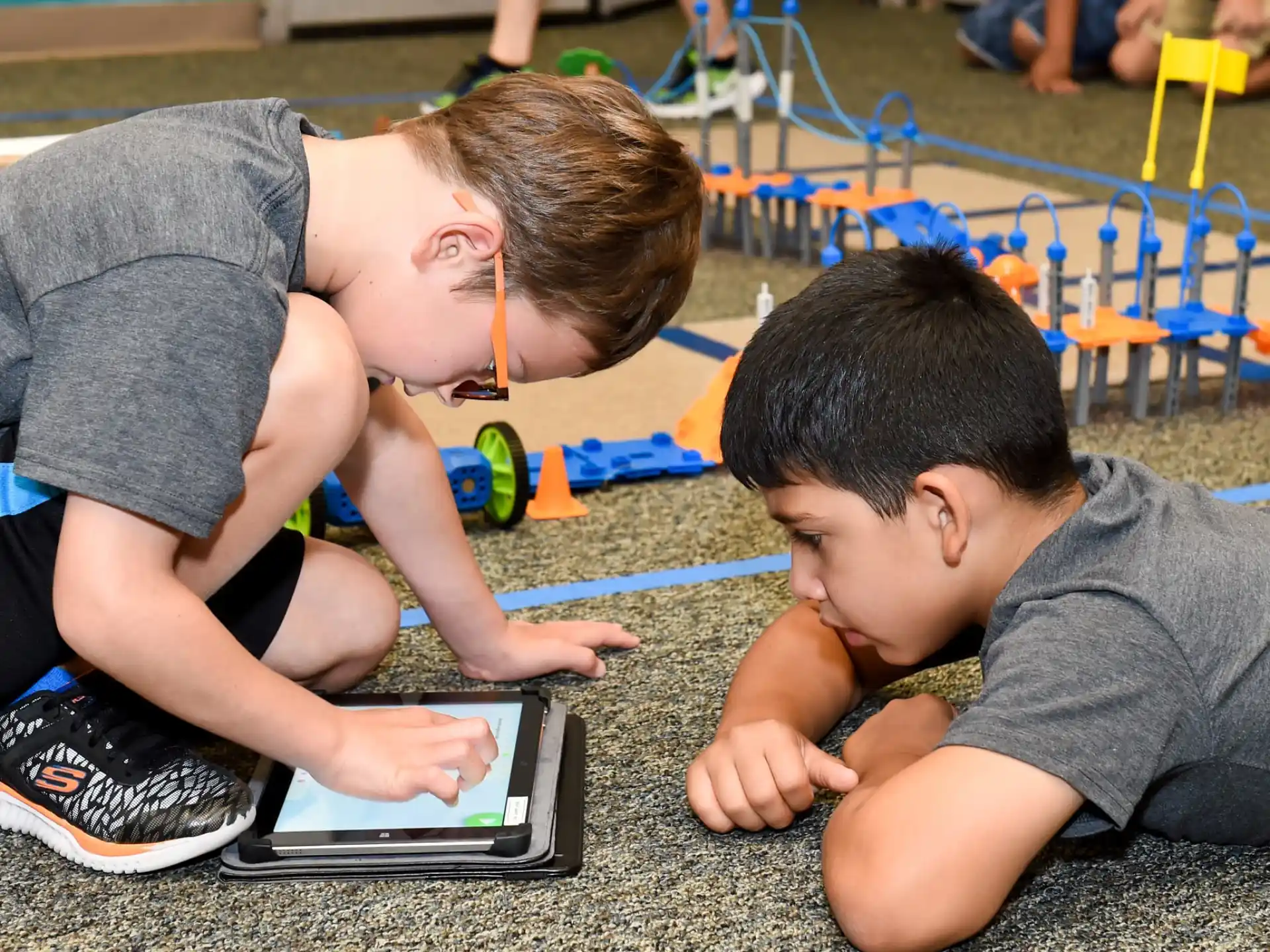 a few boys playing with a tablet