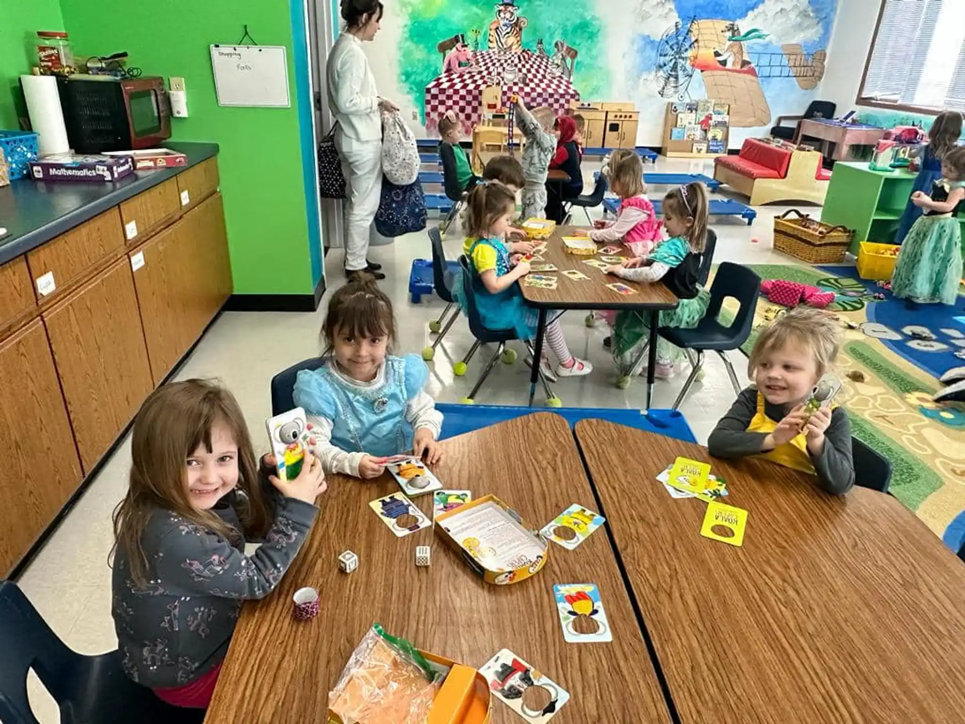 a group of children sitting at a table in a classroom