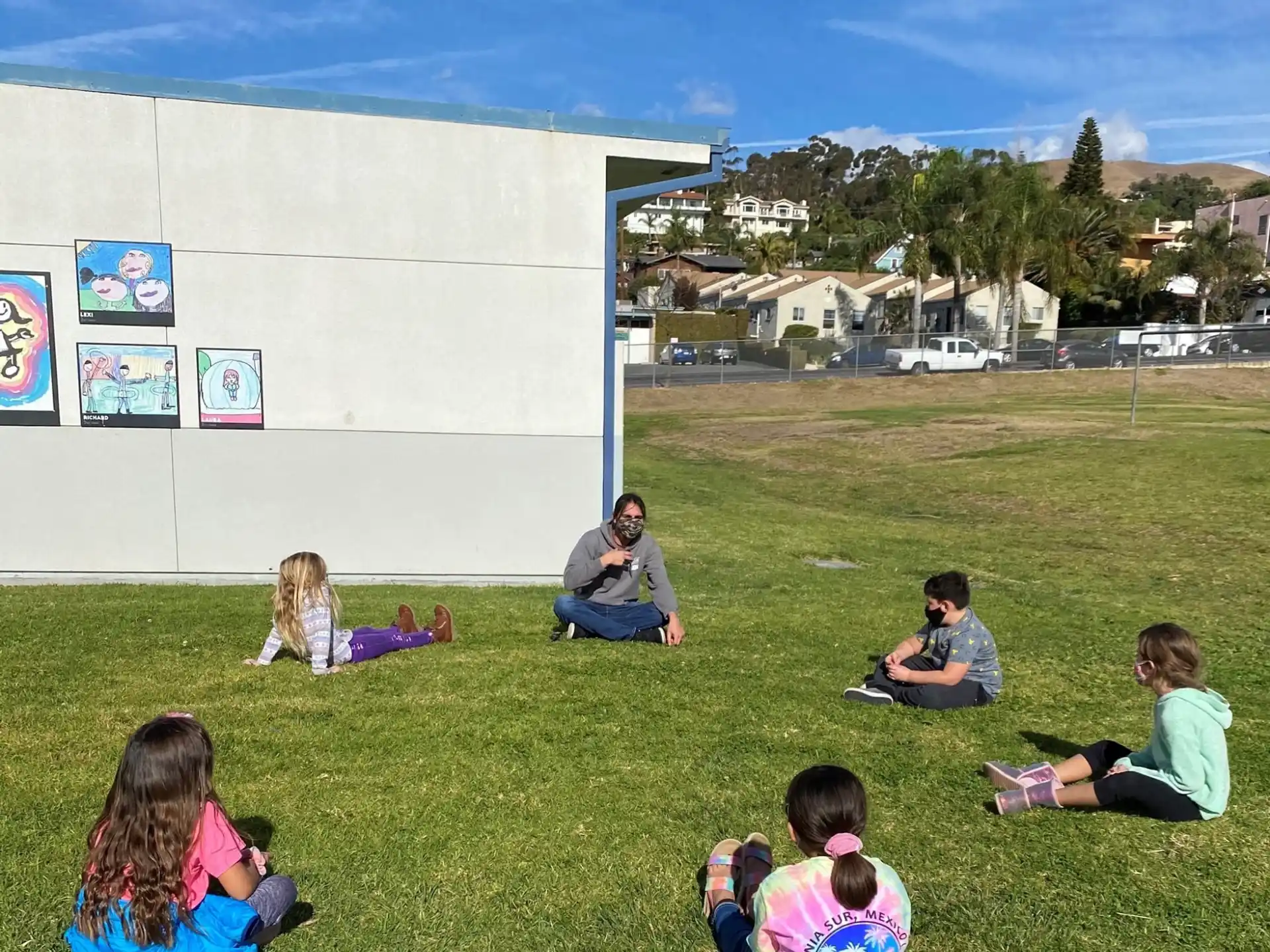 a group of people sitting on the grass