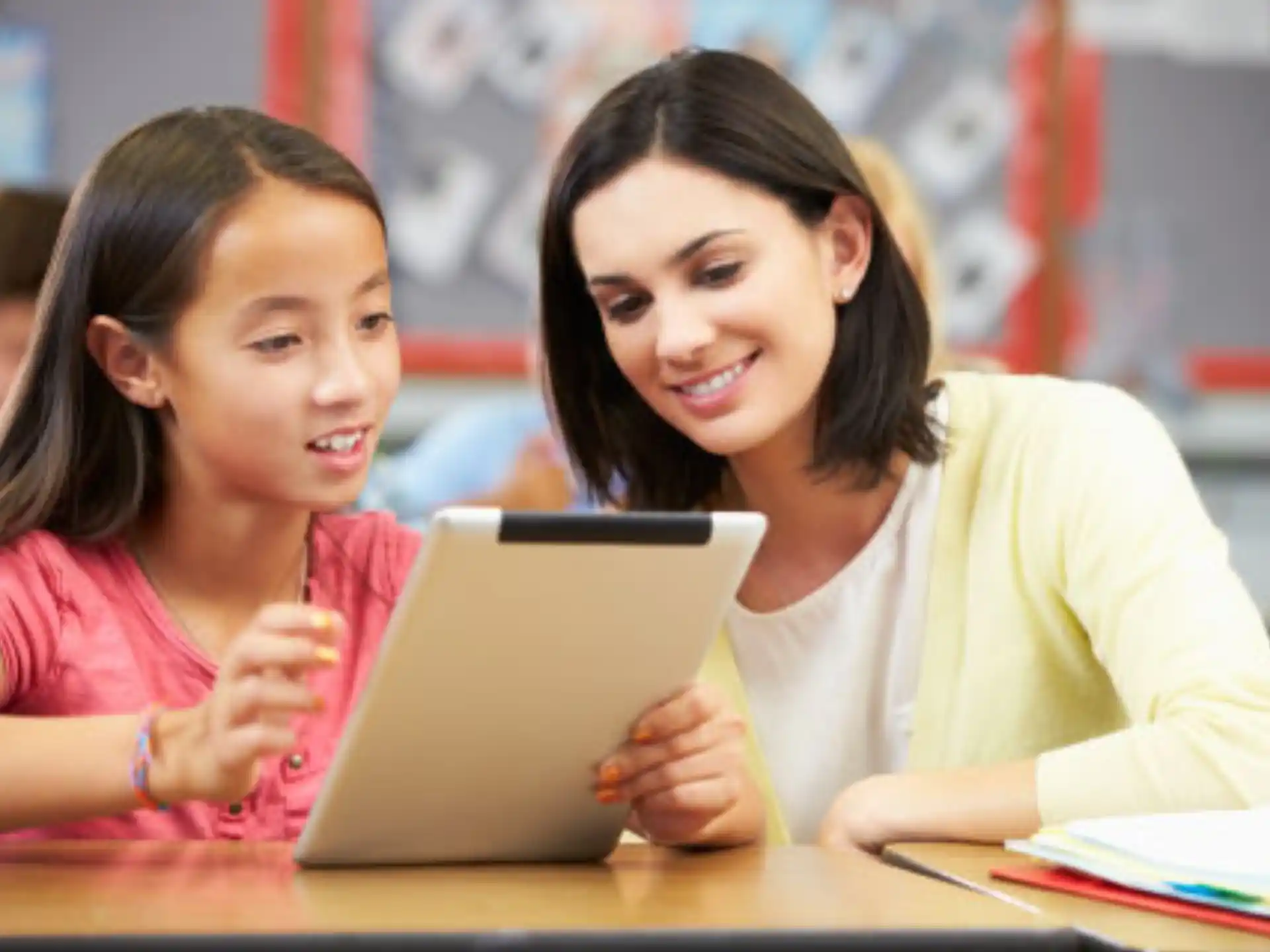 a person and a girl looking at a laptop