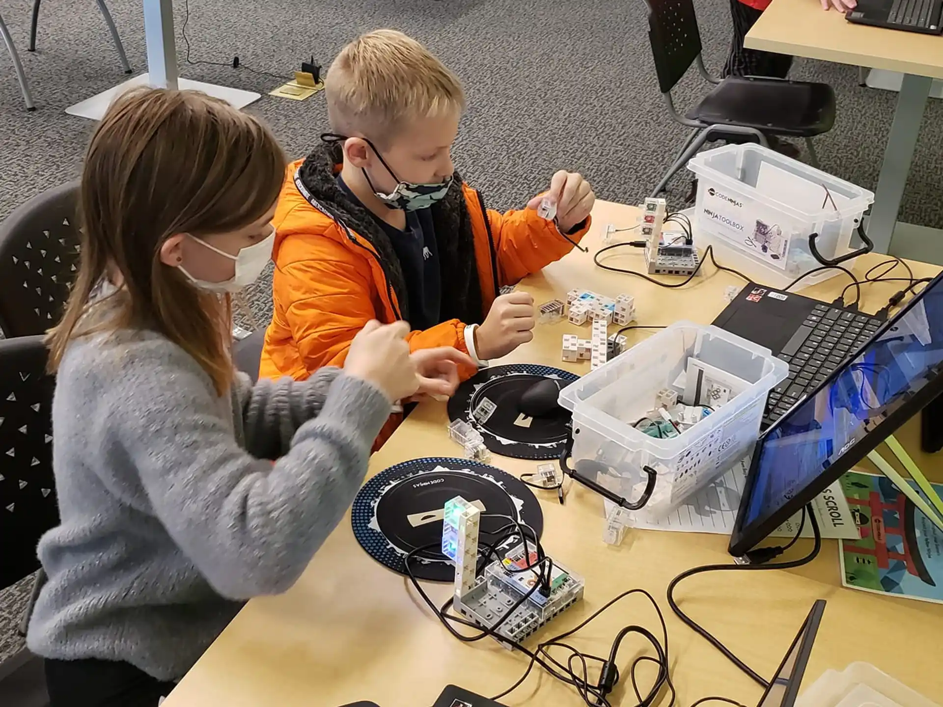 a boy and girl looking at a computer screen