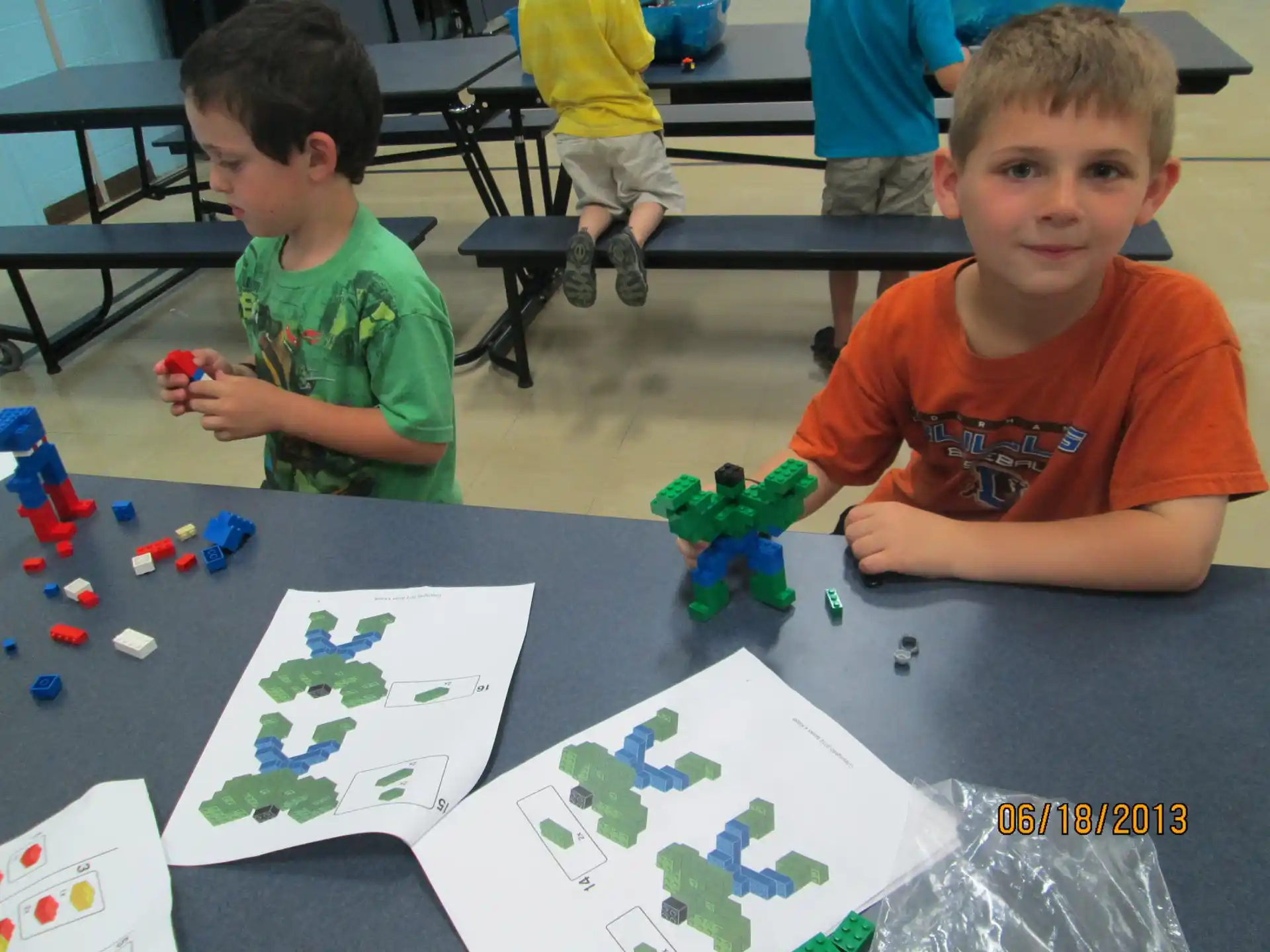 a couple of boys sitting at a table with toys and a map
