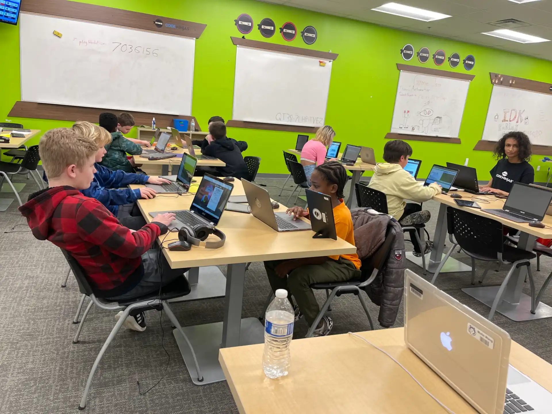 a group of people sitting at desks using laptops