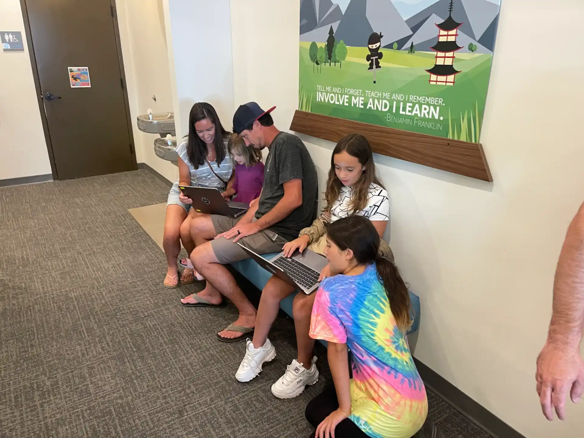 a group of people sitting on the floor using laptops