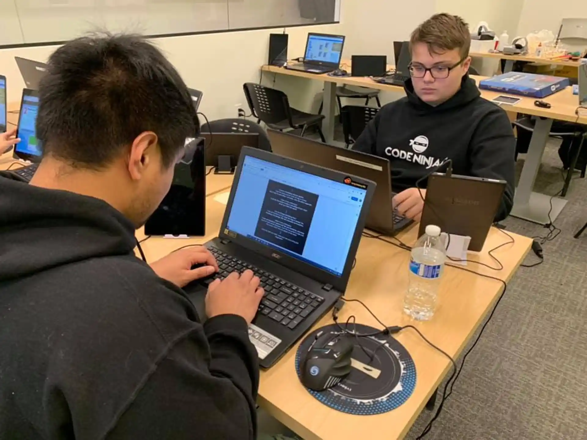 men sitting at a table with laptops