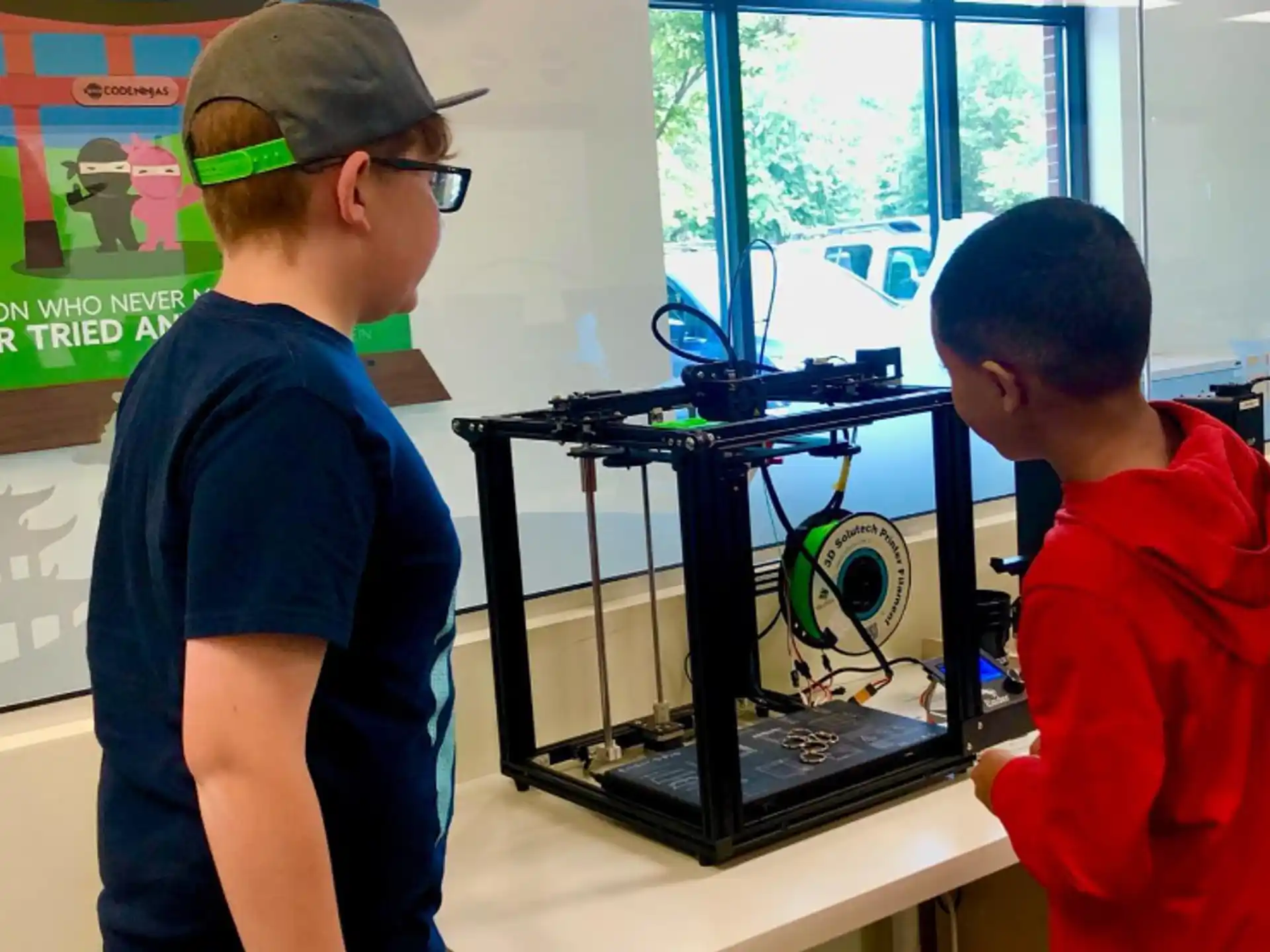 a couple of boys looking at a computer