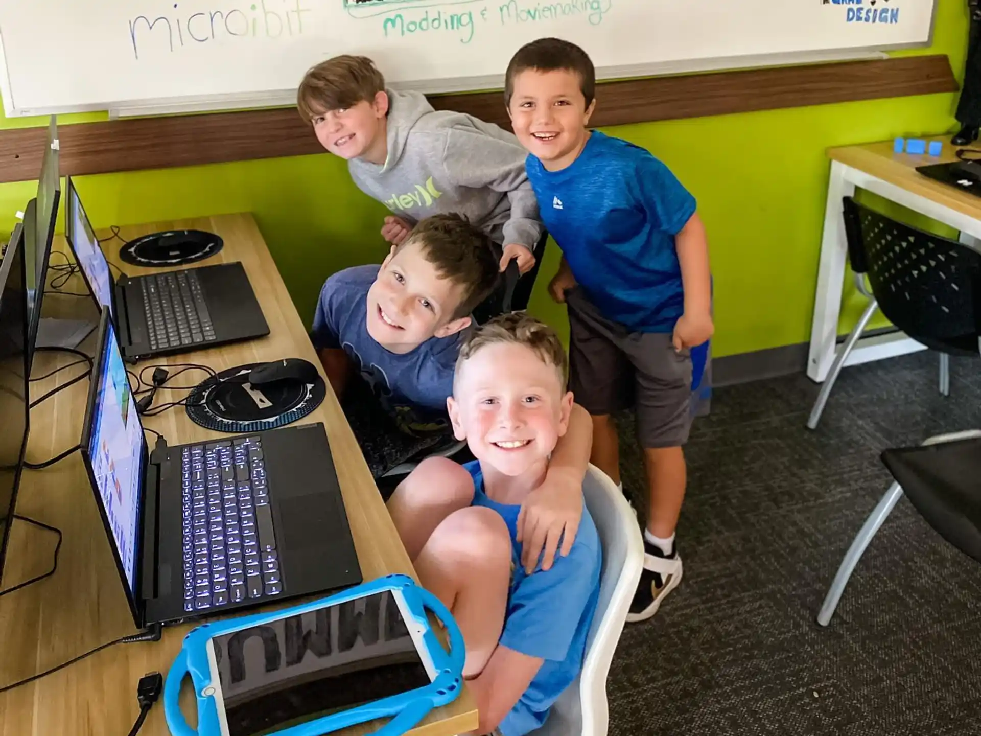 a group of boys posing for a picture with laptops