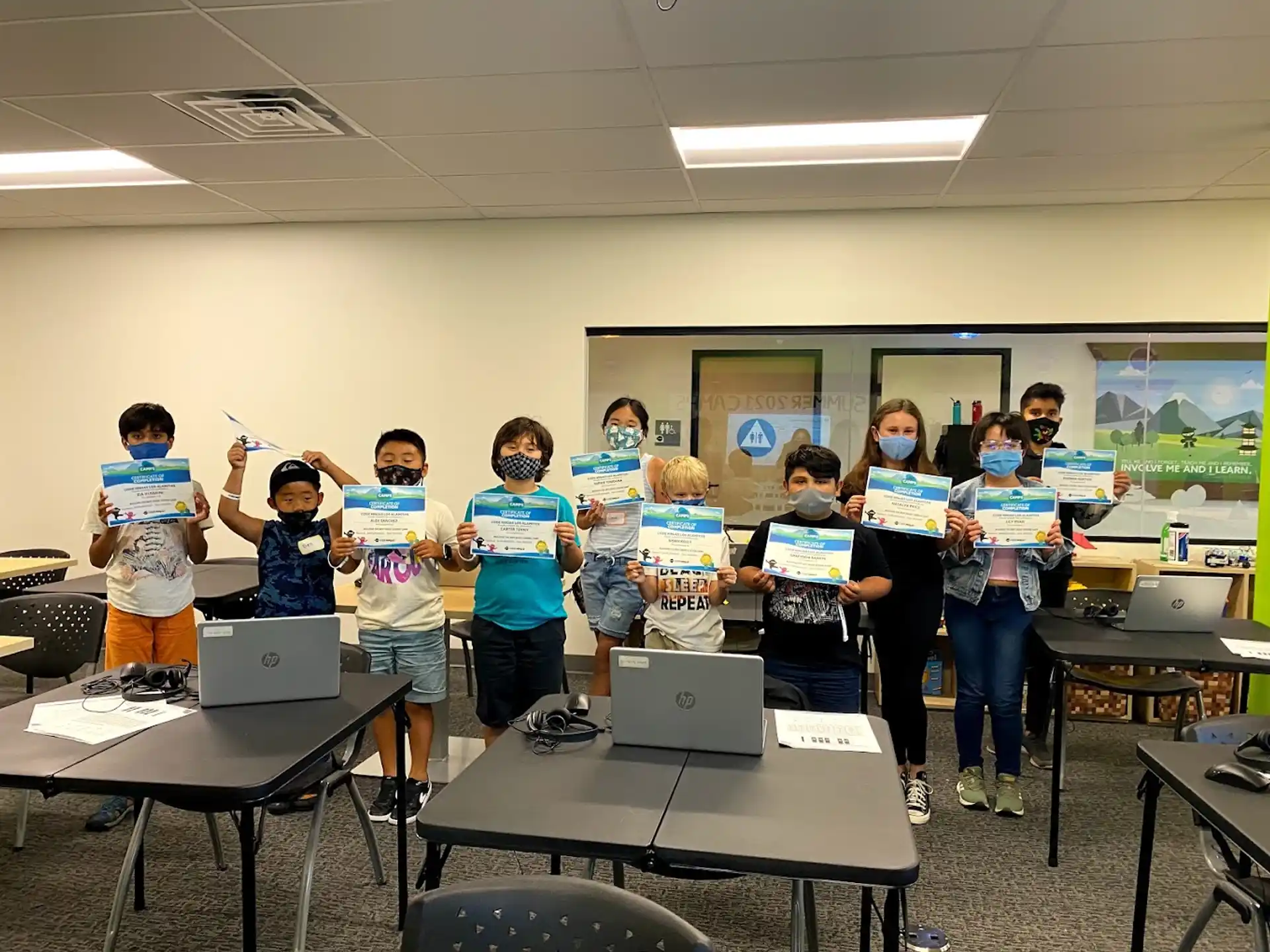 a group of children holding laptops