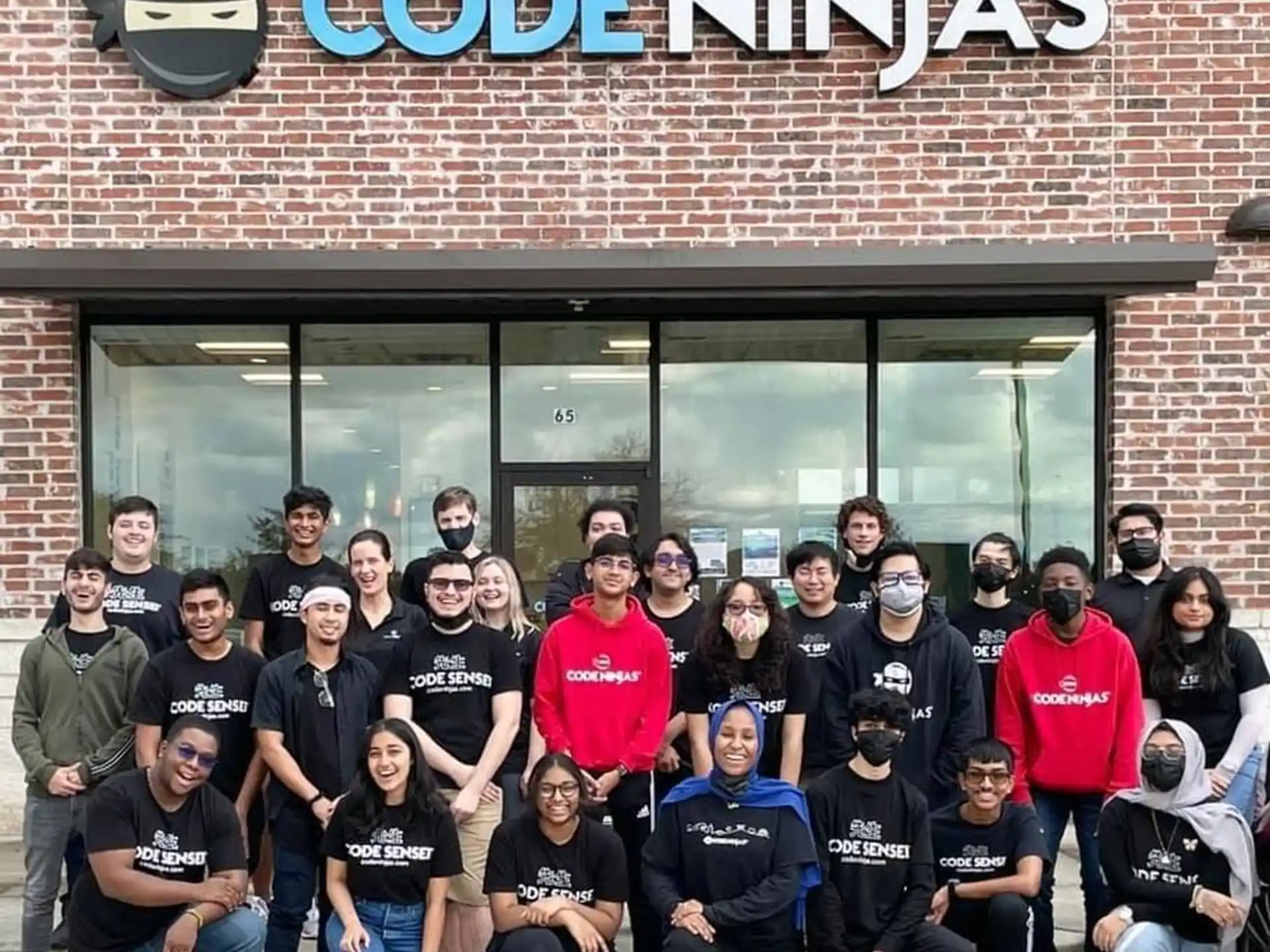 a group of people posing for a photo in front of a building