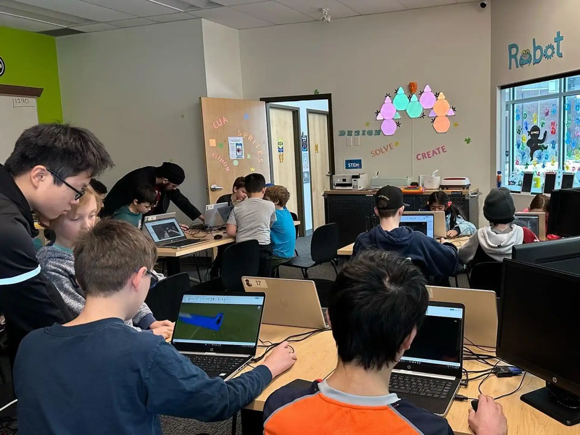 a group of people sitting at desks with laptops