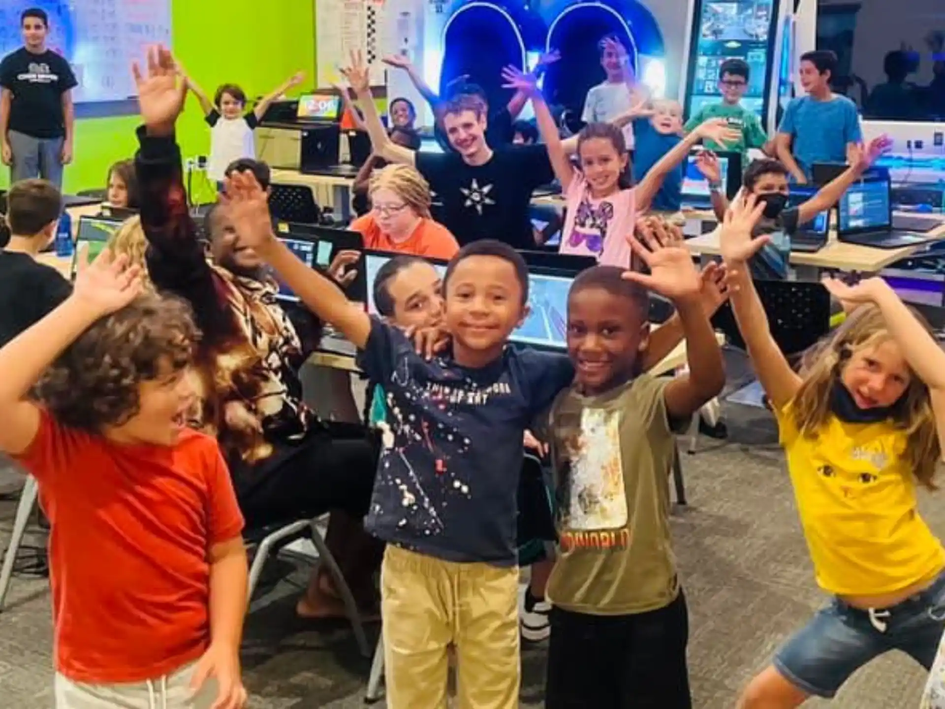 a group of children raising their hands