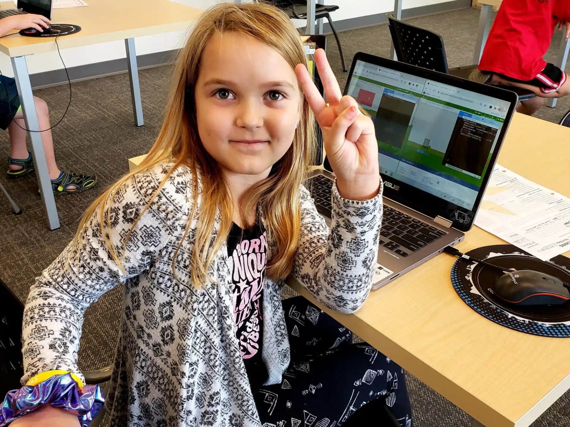 a person sitting at a desk with a laptop and a mouse
