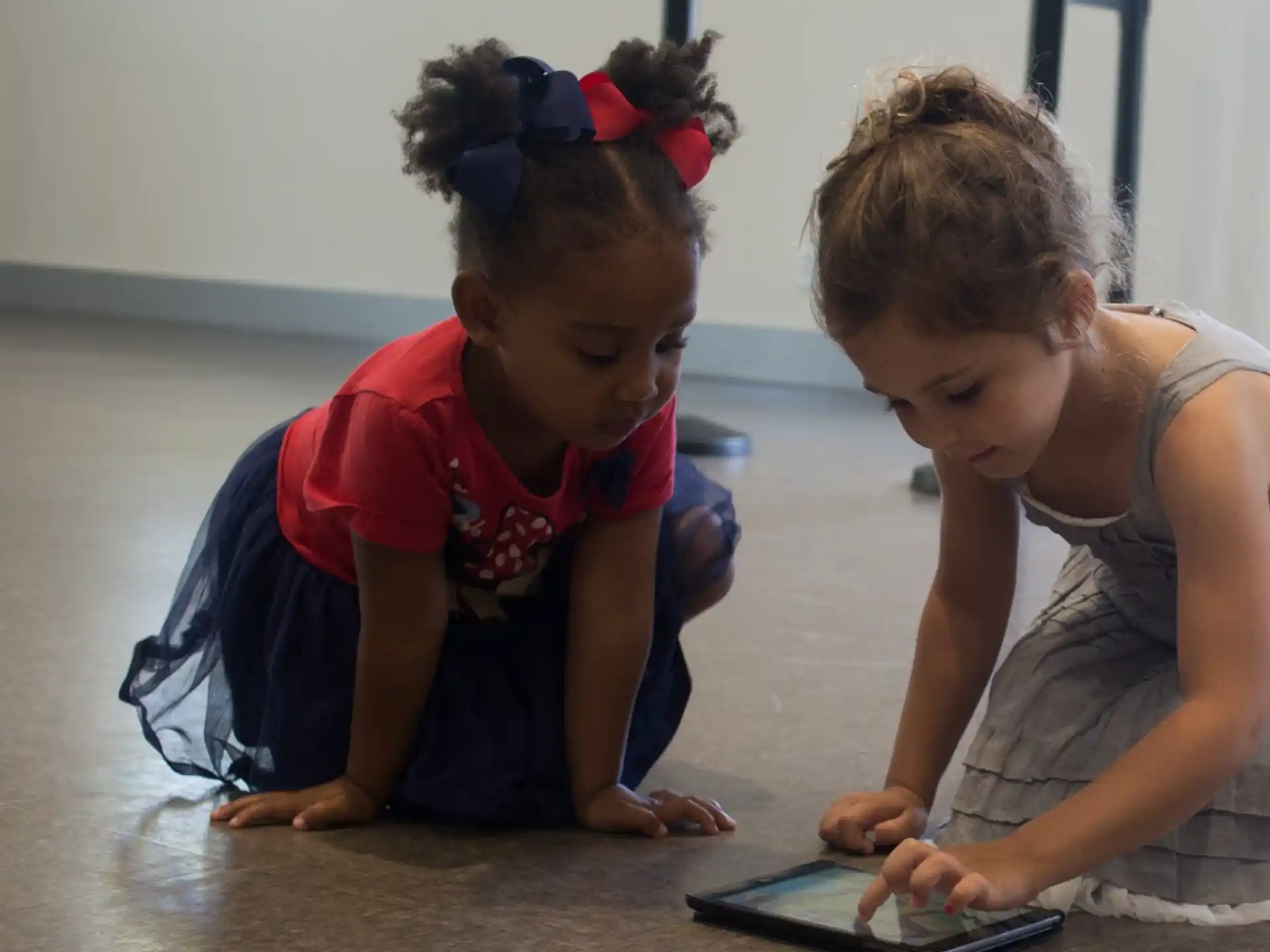 a couple of children looking at a tablet