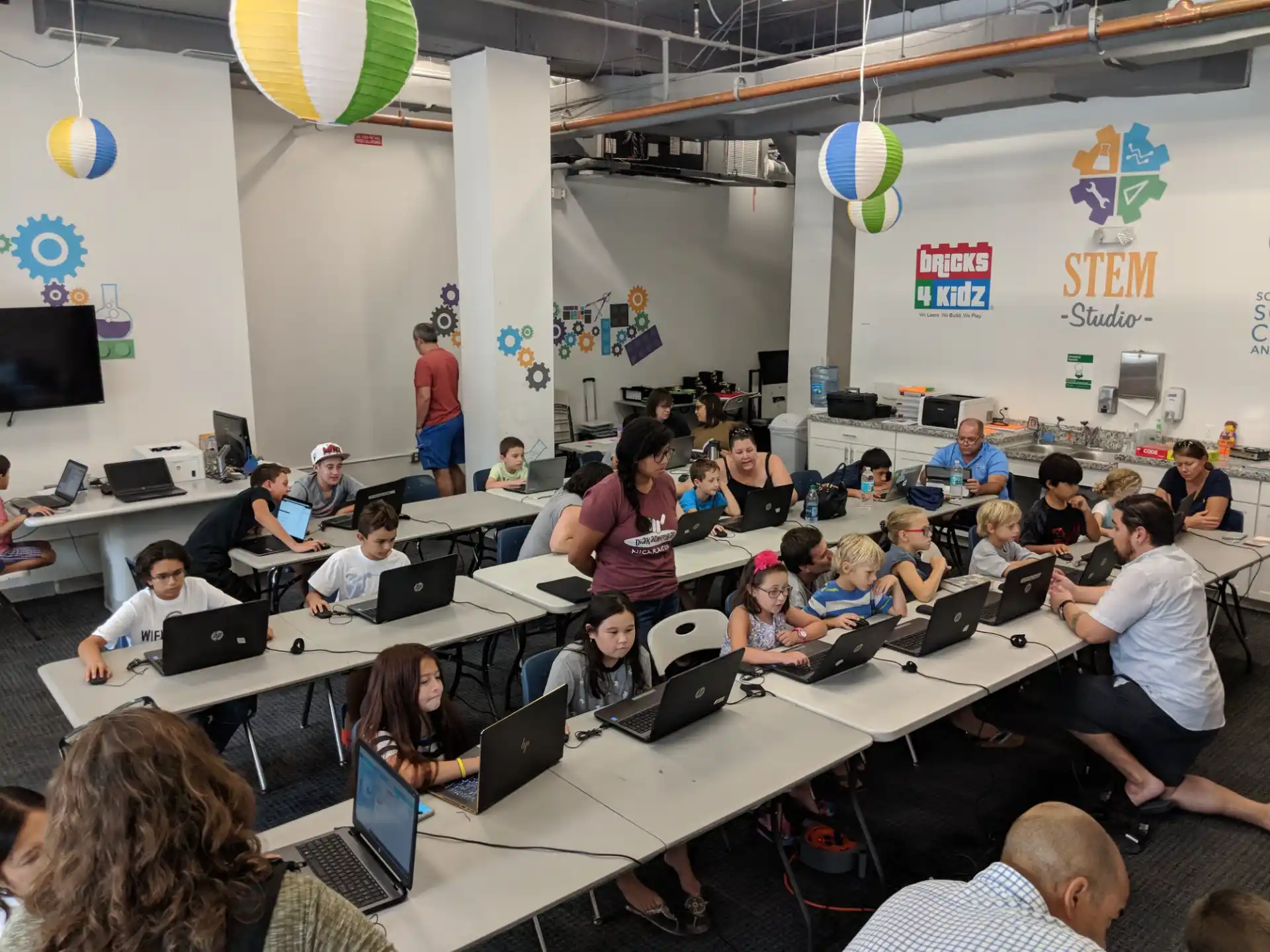 a group of people sitting at tables with laptops