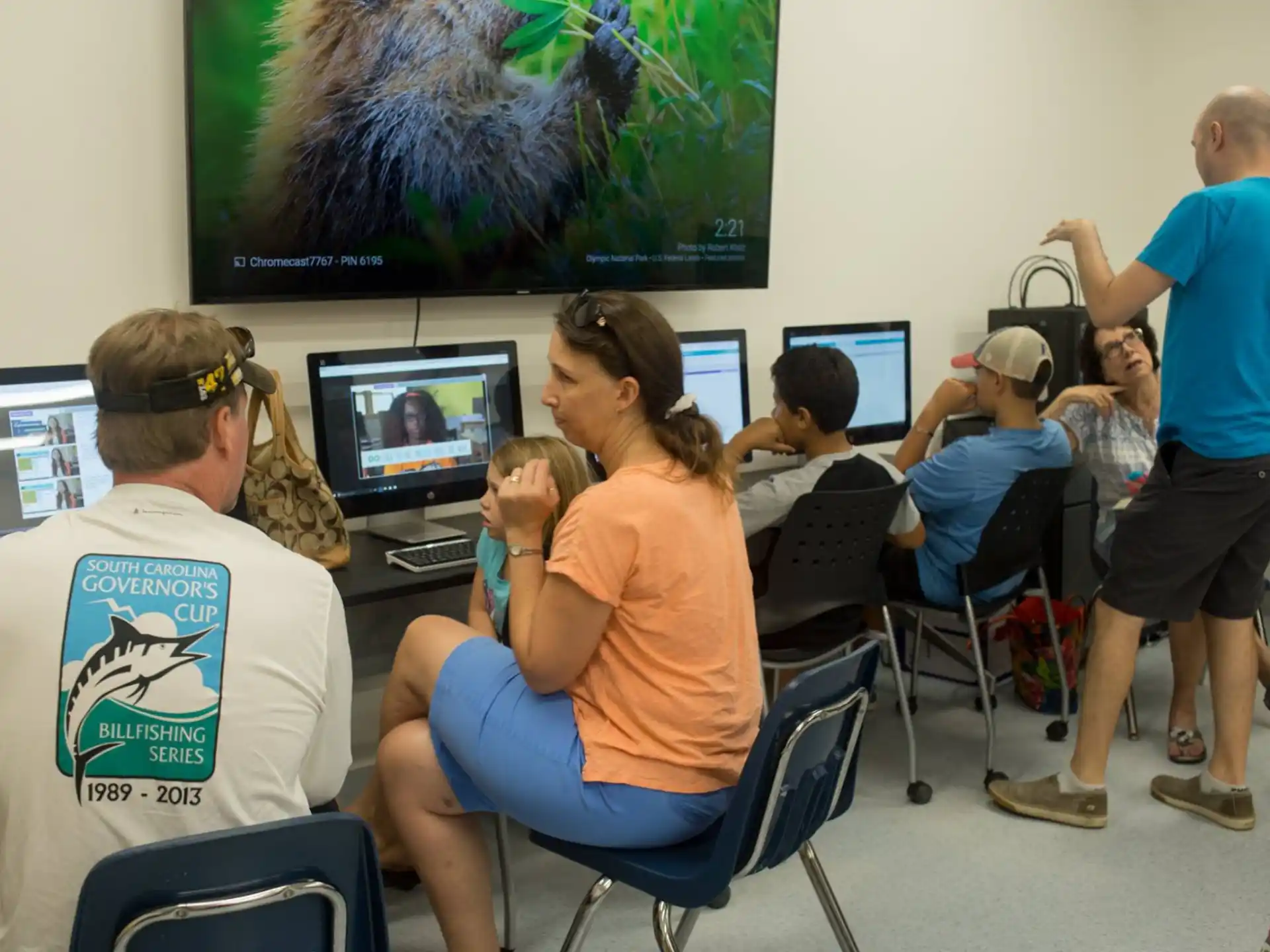 a group of people sitting in front of computers