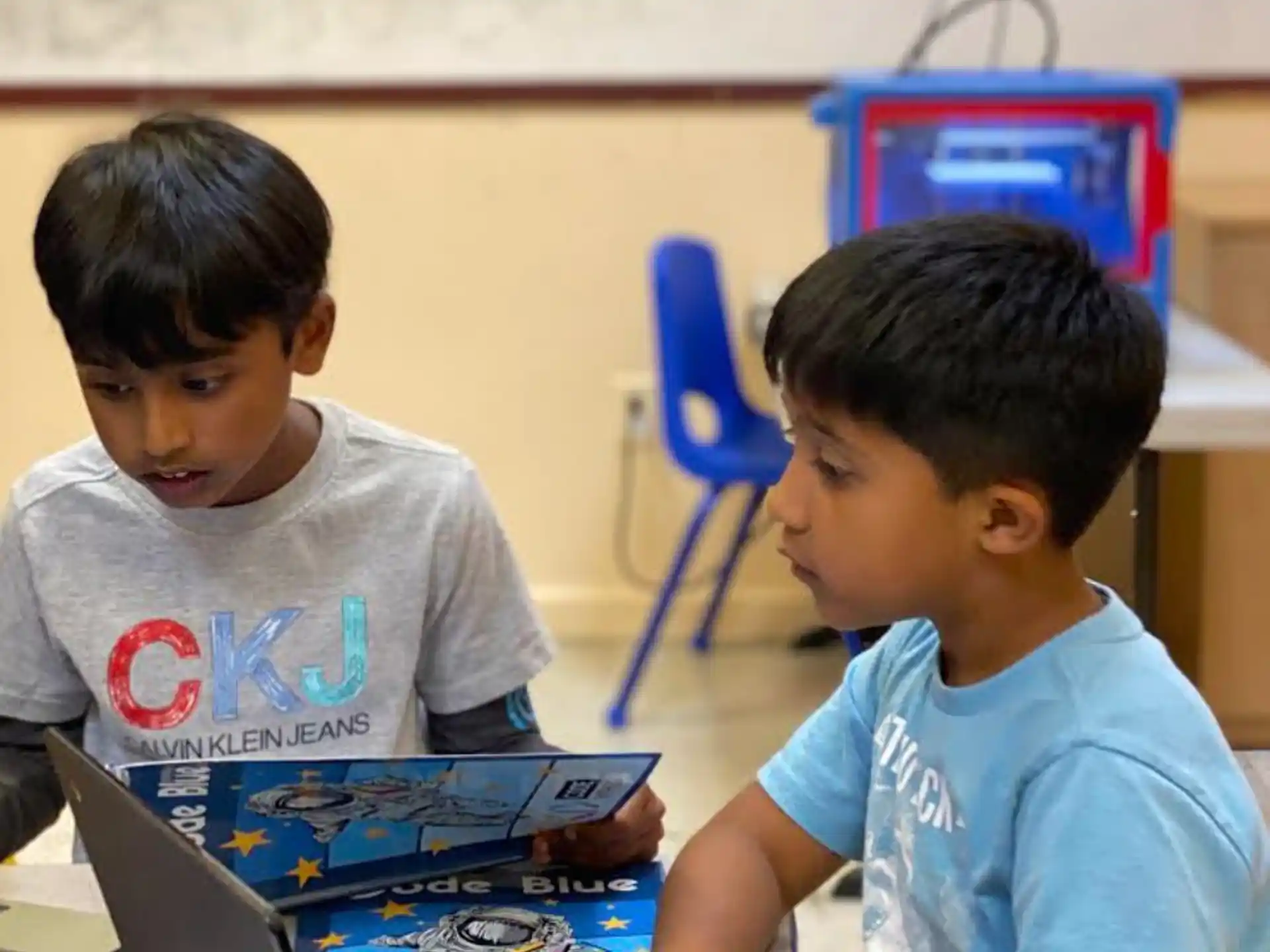 a few young boys using a laptop