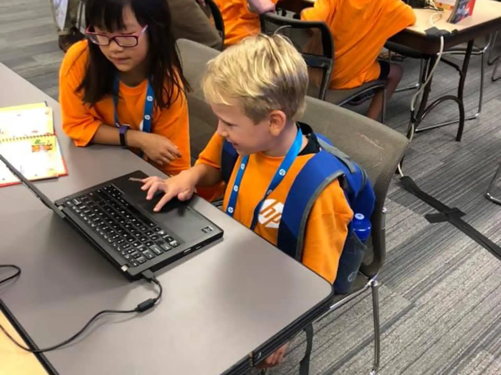 children using laptops in a classroom