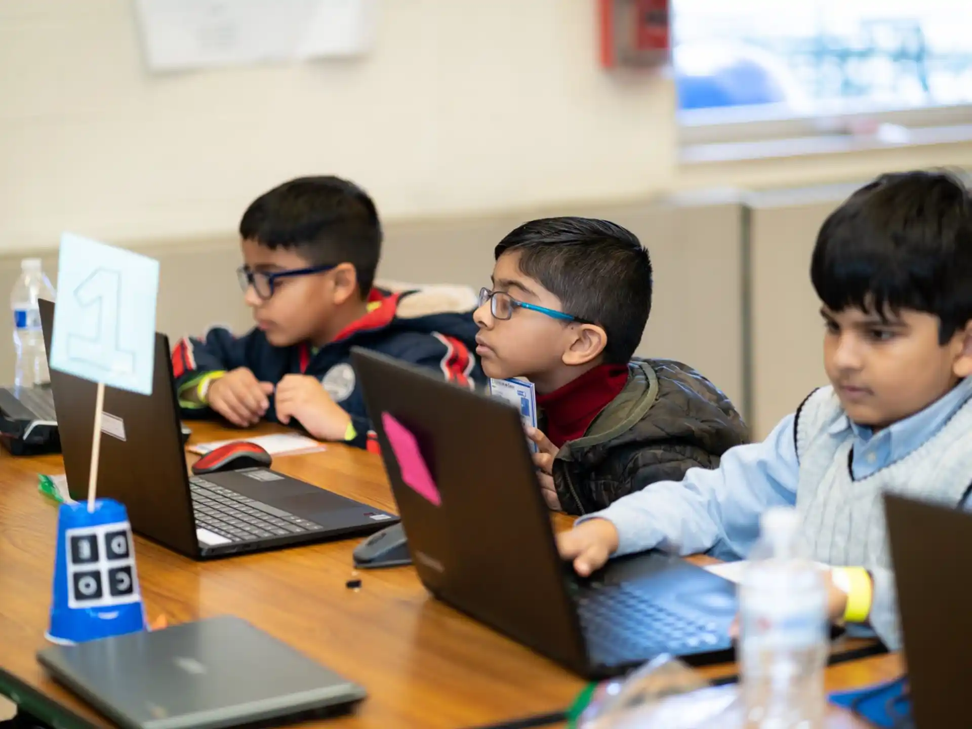 a group of boys using laptops