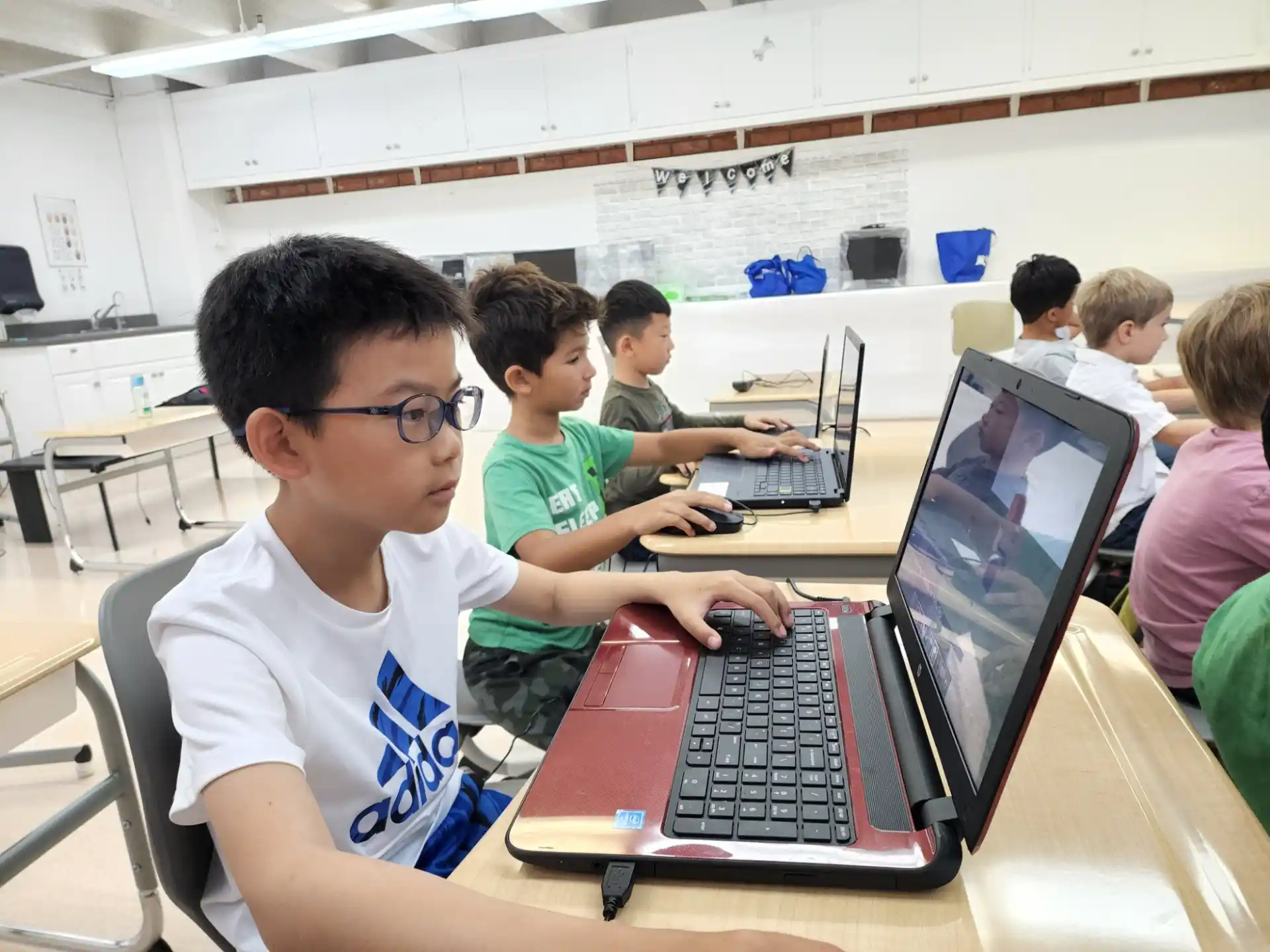 a group of children using laptops