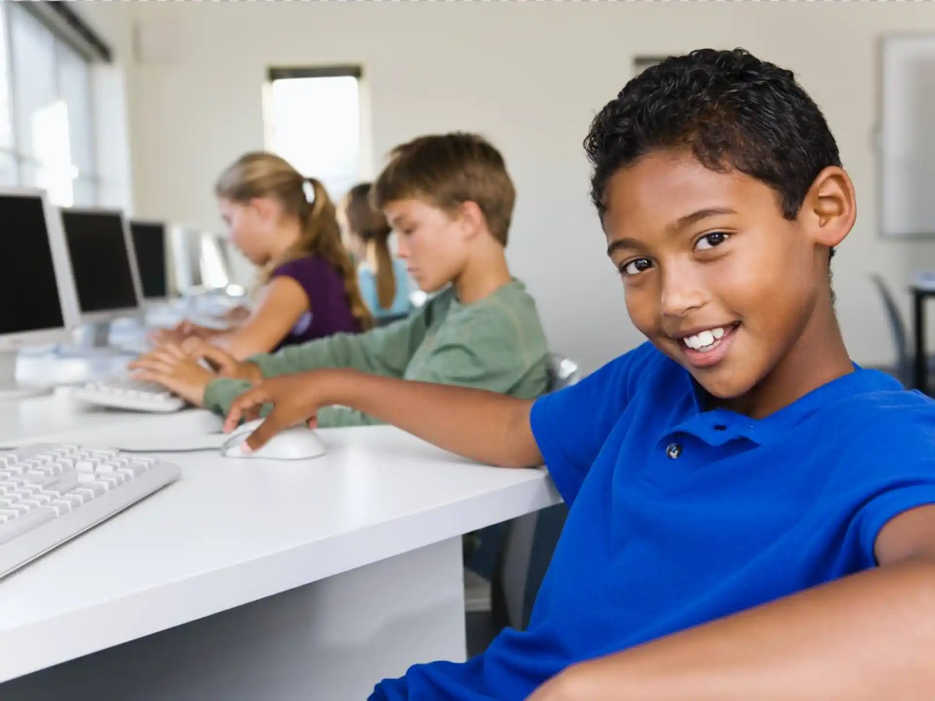 a group of people sitting at a table with computers