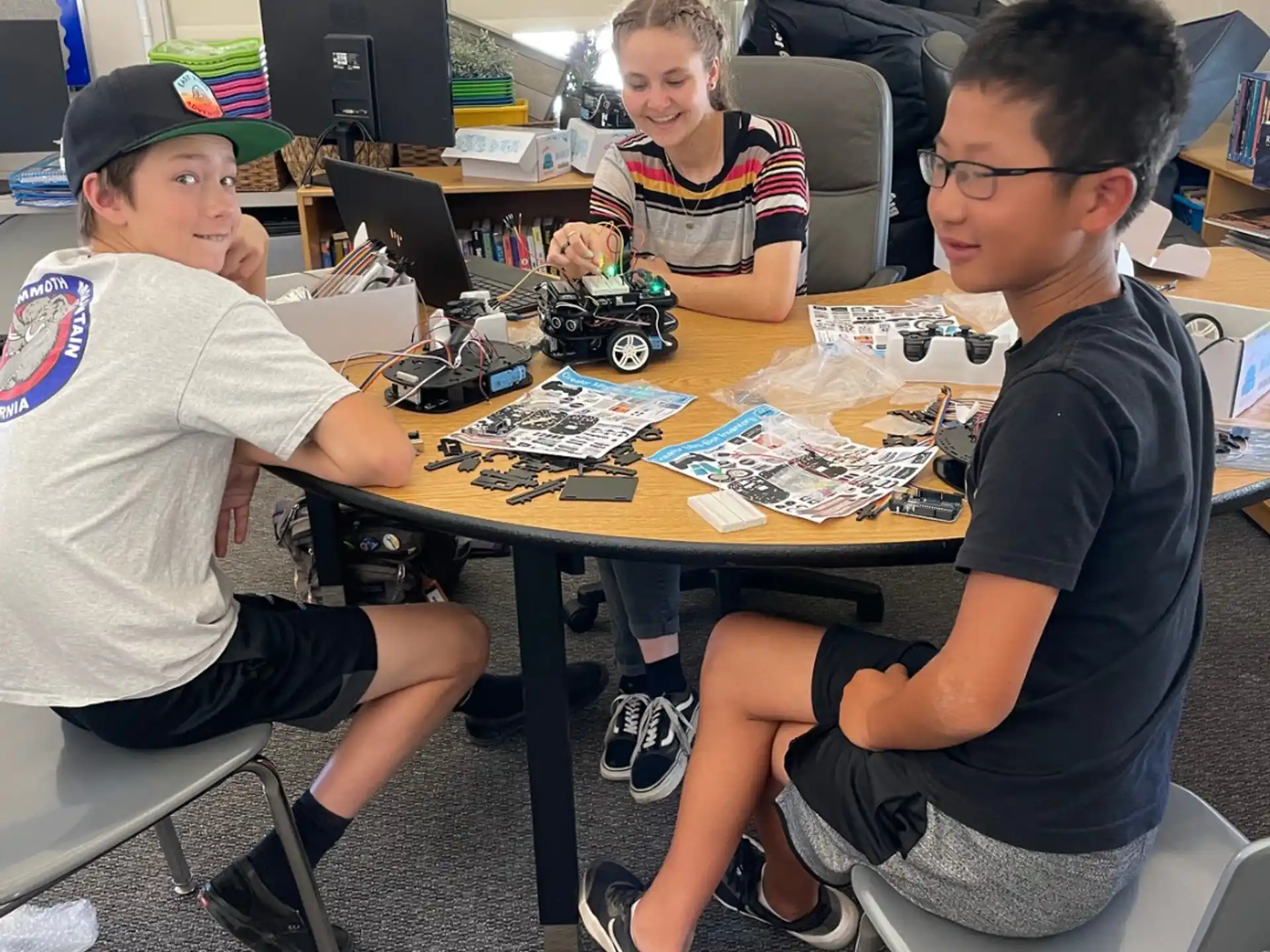 a group of boys sitting at a table playing a board game