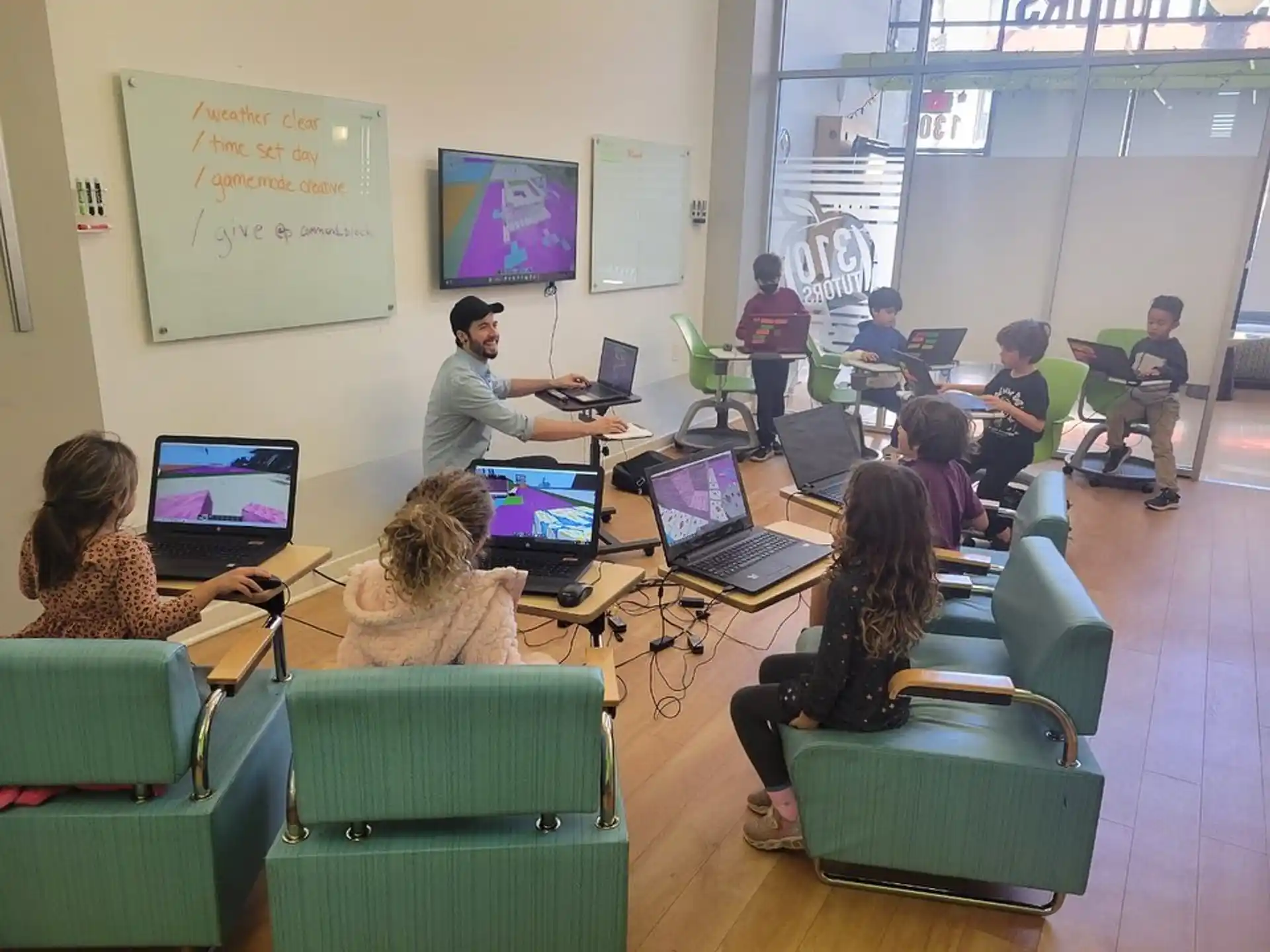 a group of people sitting at desks with laptops