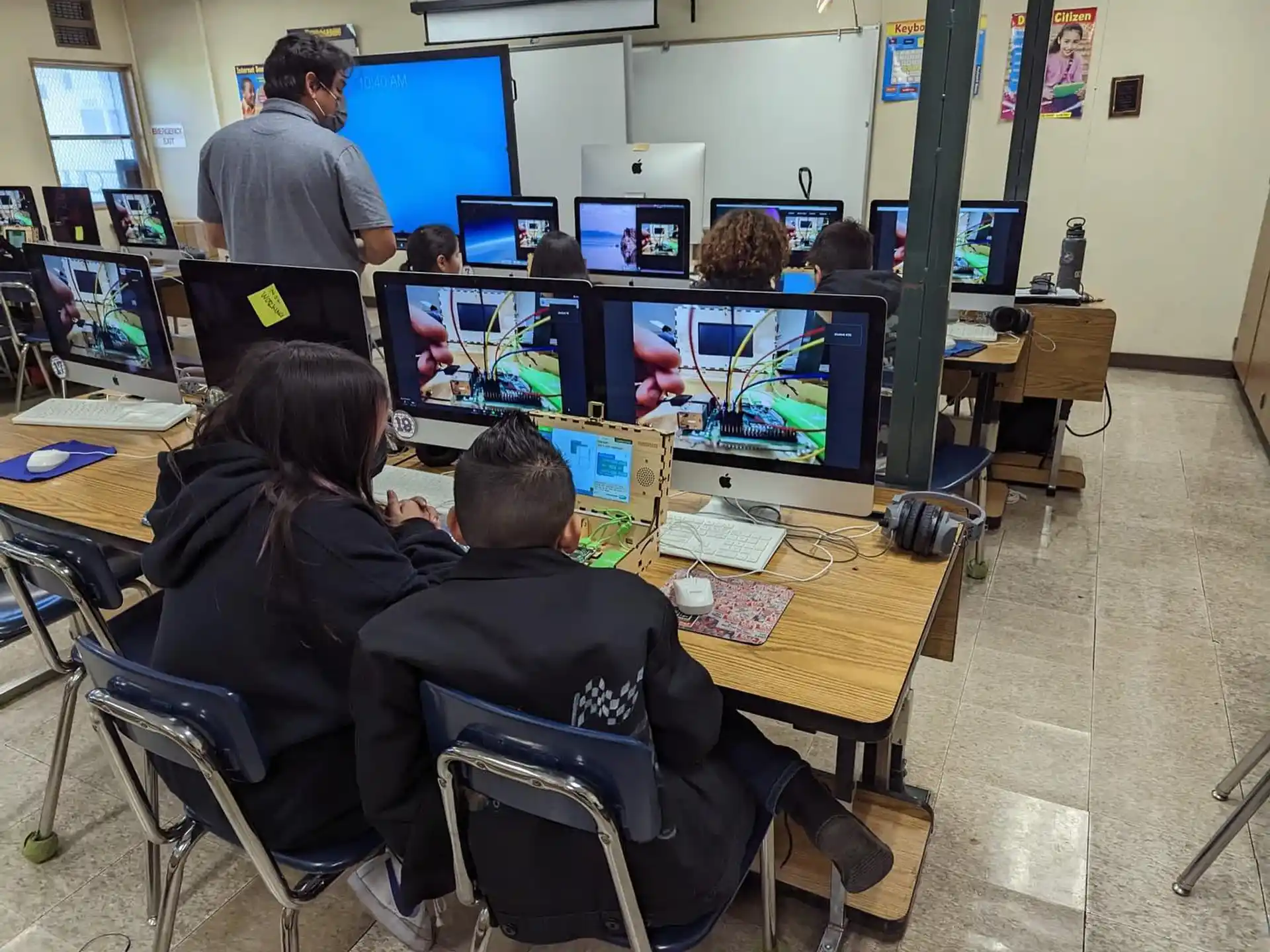 a group of people sitting at a table with computers