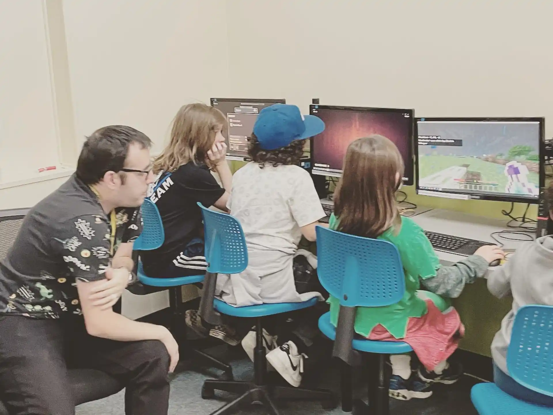 a group of people sitting in front of a computer