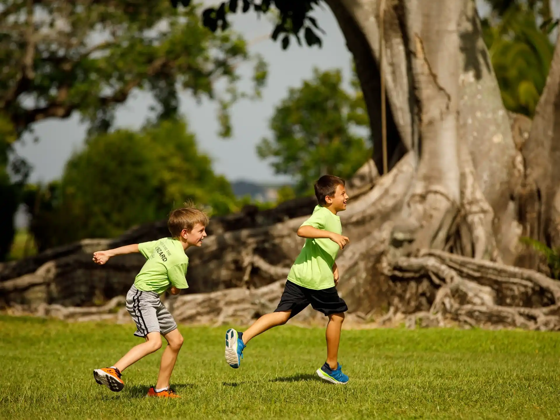 two boys running on grass