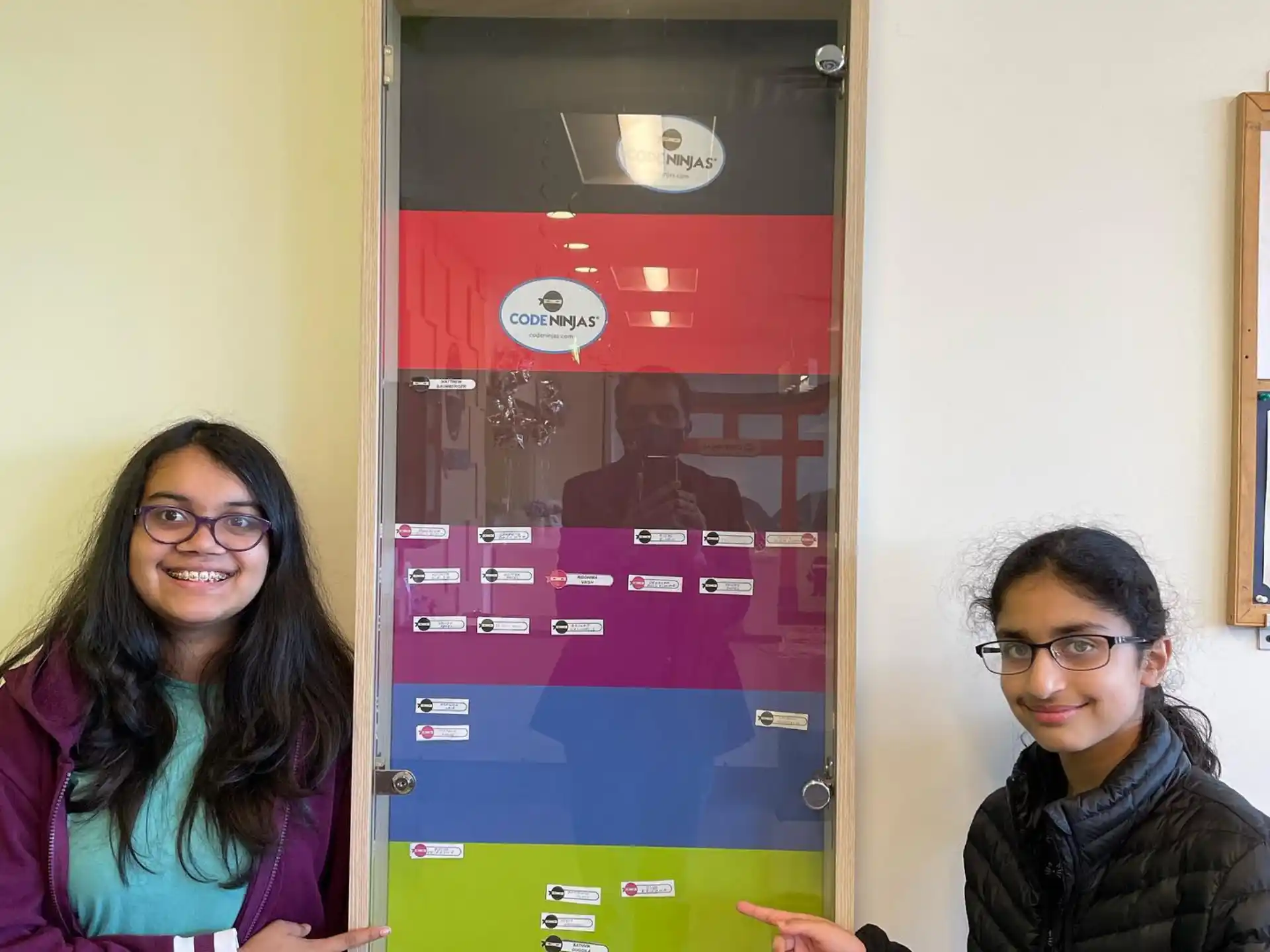 two women standing next to a machine
