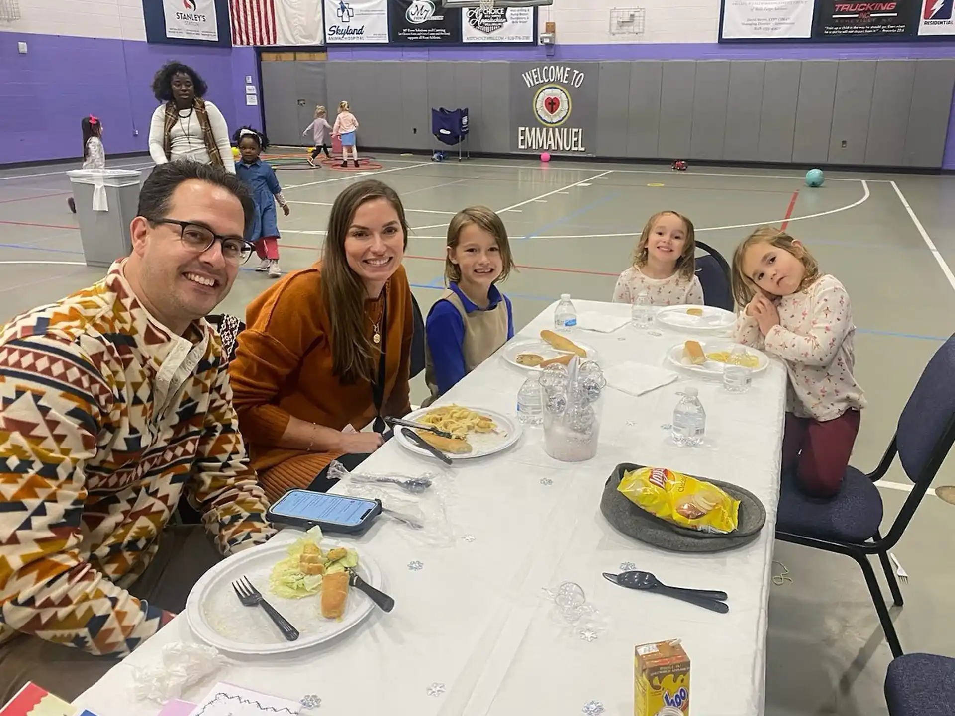 a group of people sitting at a table with food